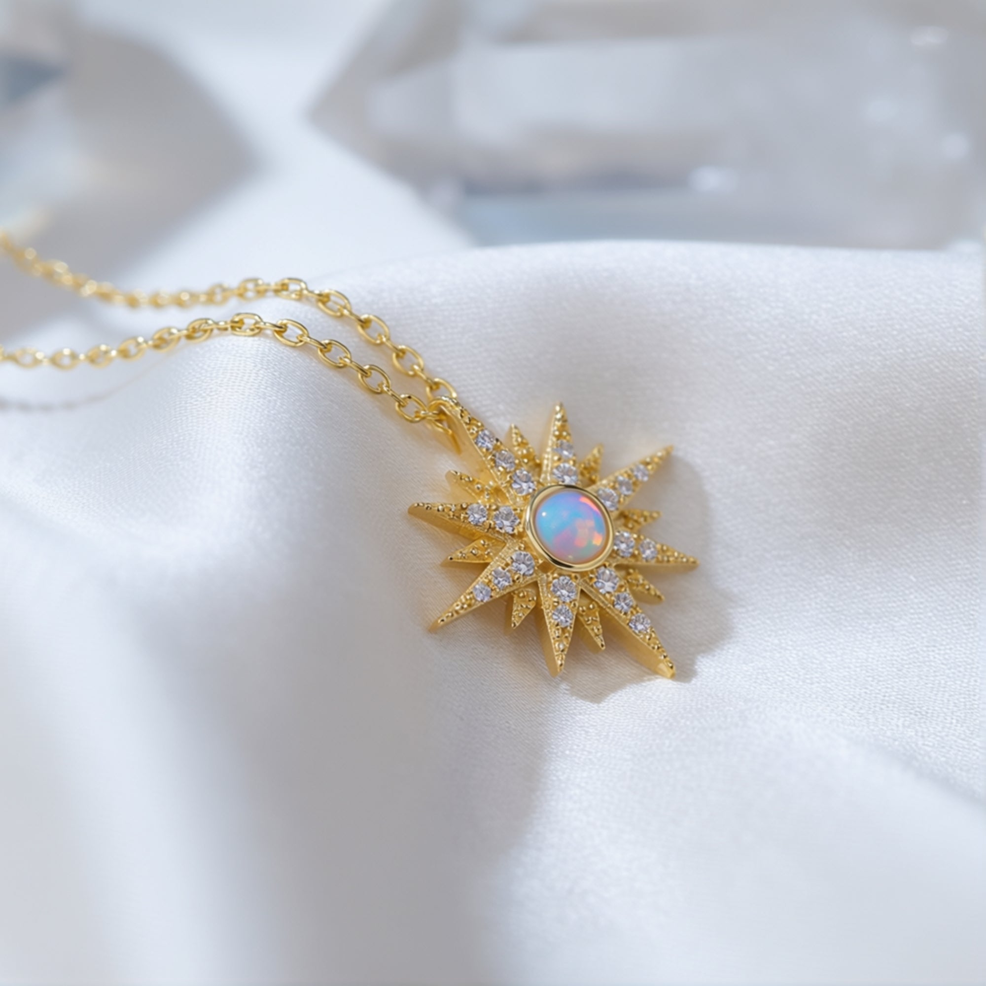 Macro detail of the gold starburst pendant featuring a round natural white opal and clear accent stones.