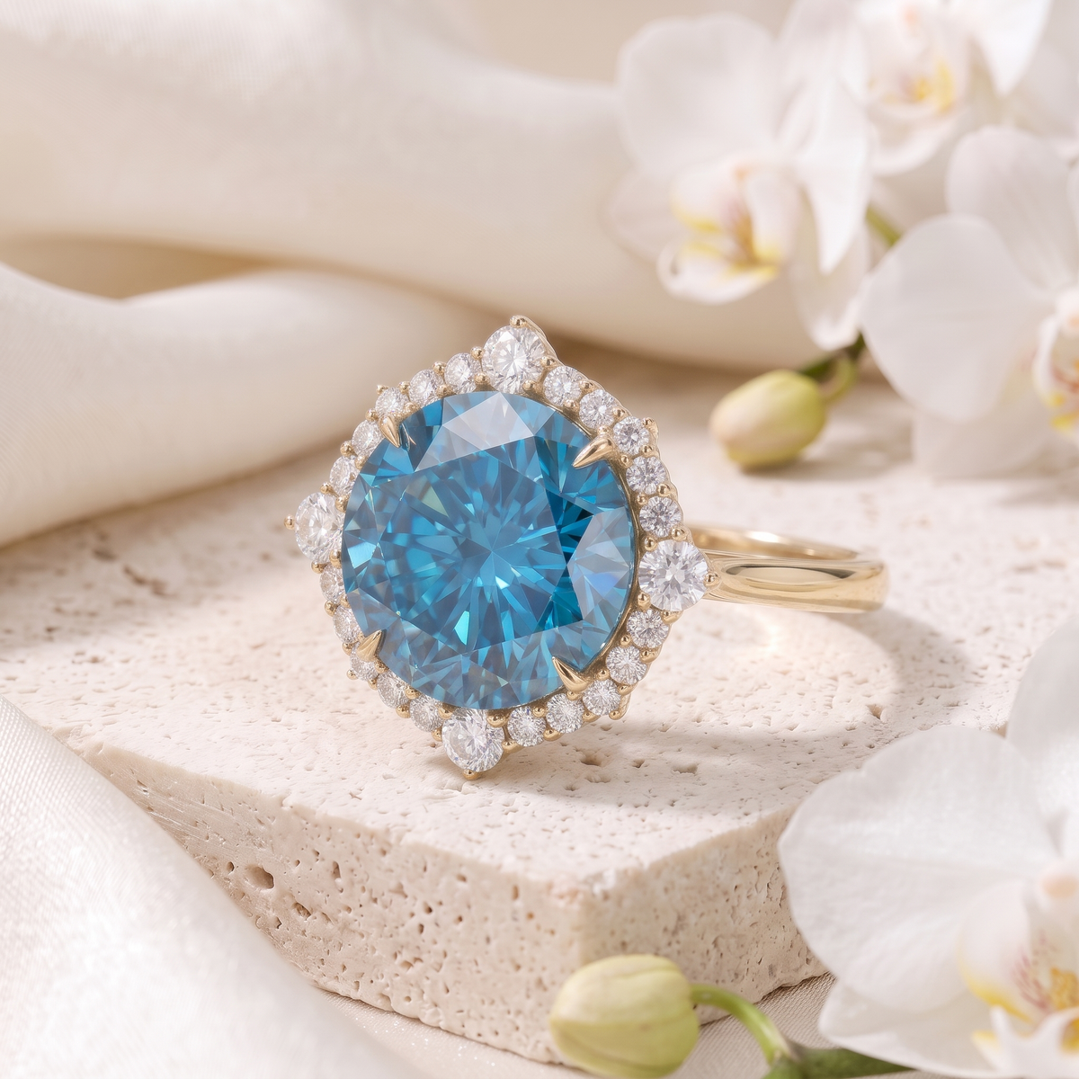 Angled view of a yellow gold blue moissanite halo ring resting on a stone pedestal.
