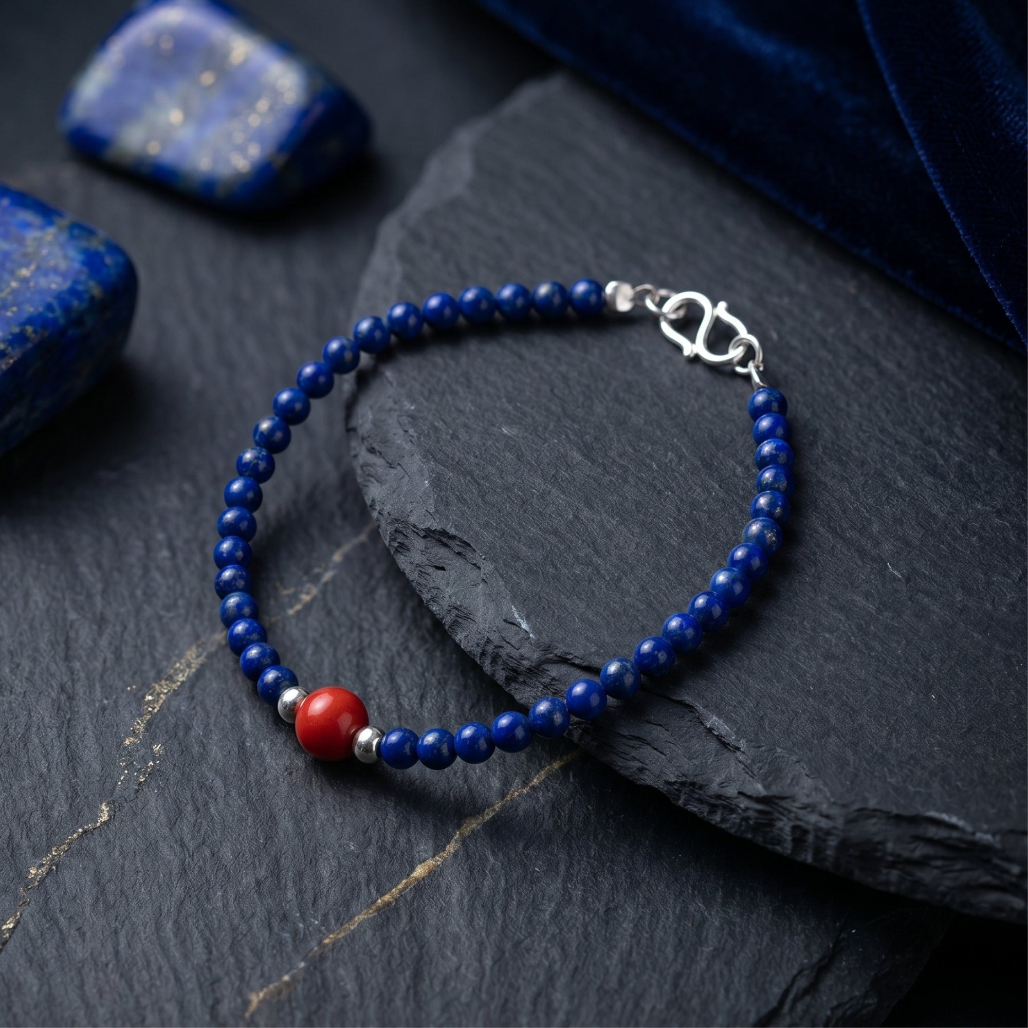 Close-up of the Azure Trace natural lapis beads and silver clasp resting on a dark stone surface.