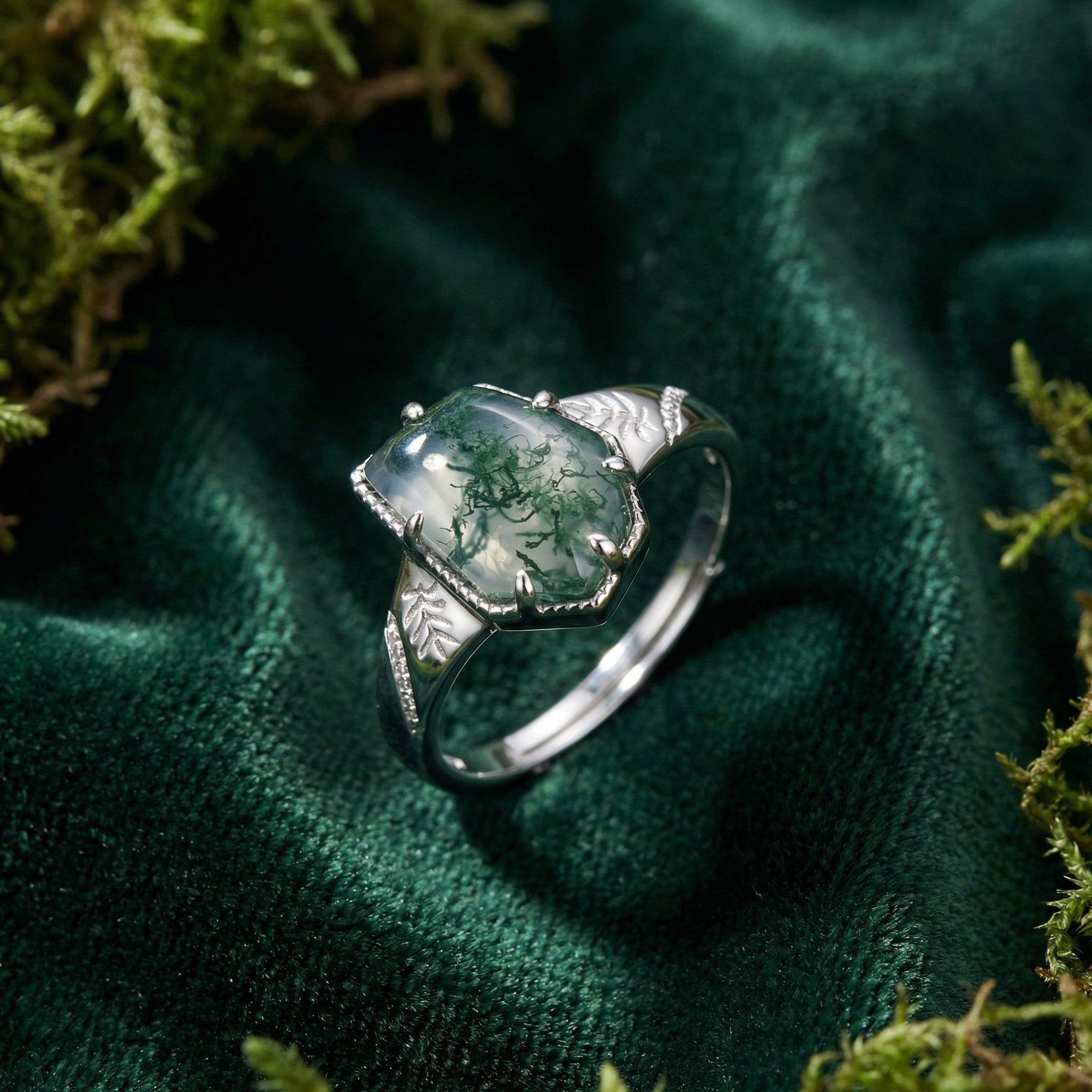 Close-up of a cushion cut moss agate ring in S925 sterling silver with intricate leaf designs on the band.