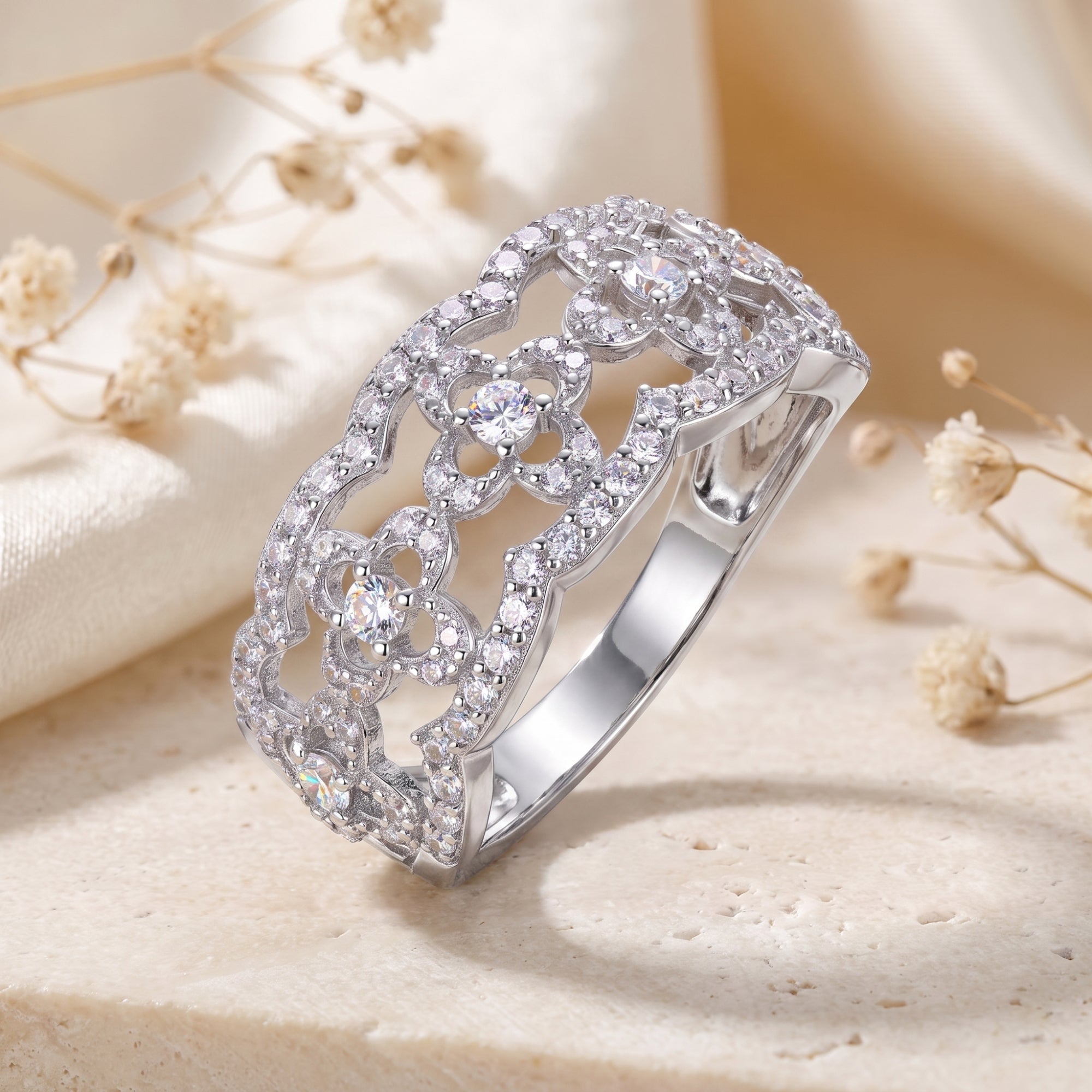 Close-up of clover lattice filigree and round simulated diamonds on an S925 sterling silver ring.