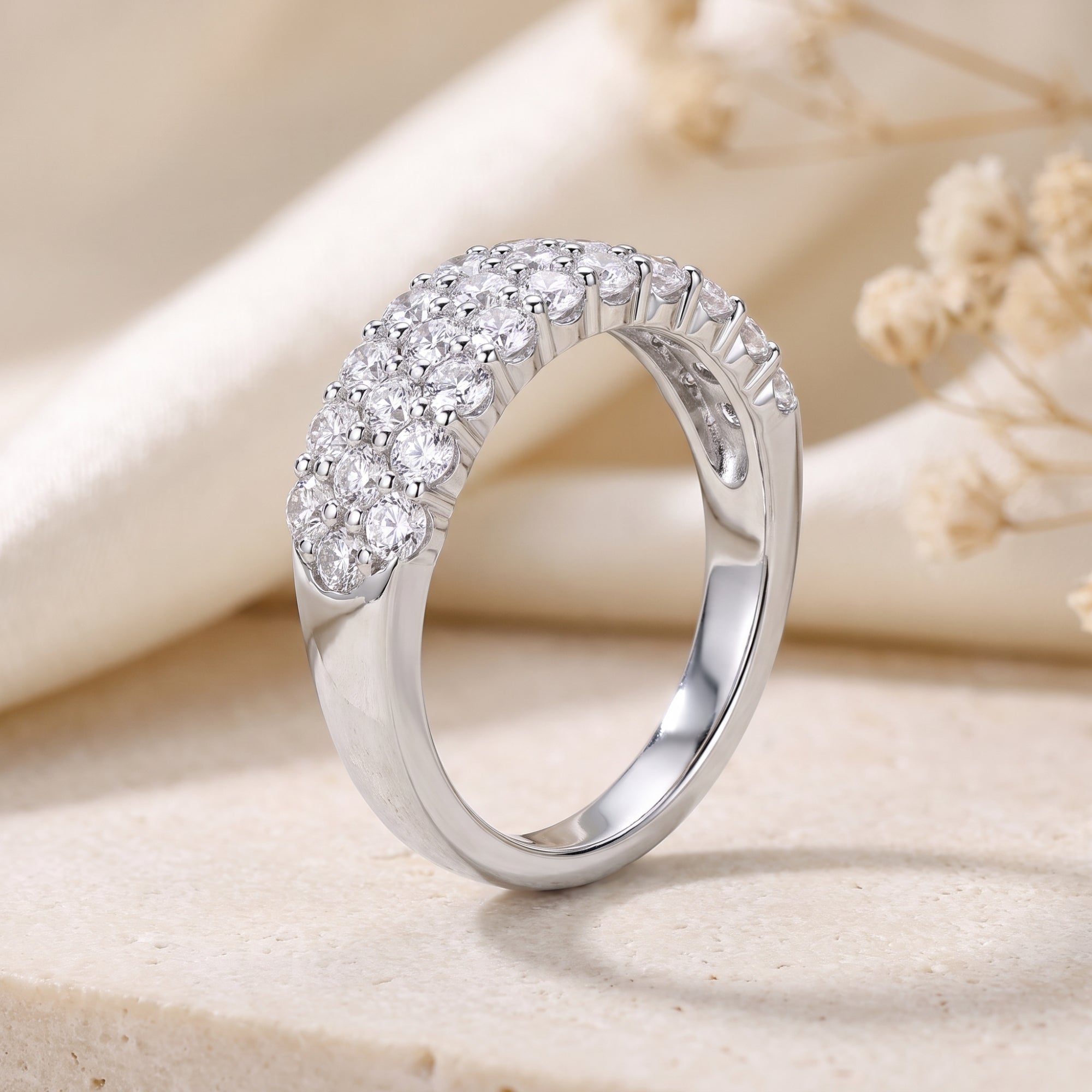 Profile view of a three-row round cubic zirconia pavé ring in sterling silver.
