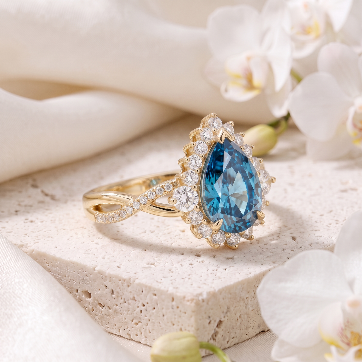 Side perspective view of a pear cut blue moissanite halo engagement ring in yellow gold.