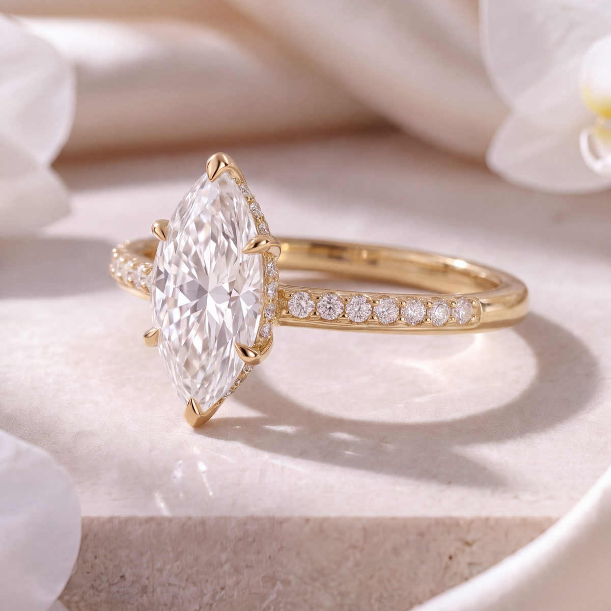 Side-profile view of a yellow gold marquise moissanite ring featuring a pavé accented band.