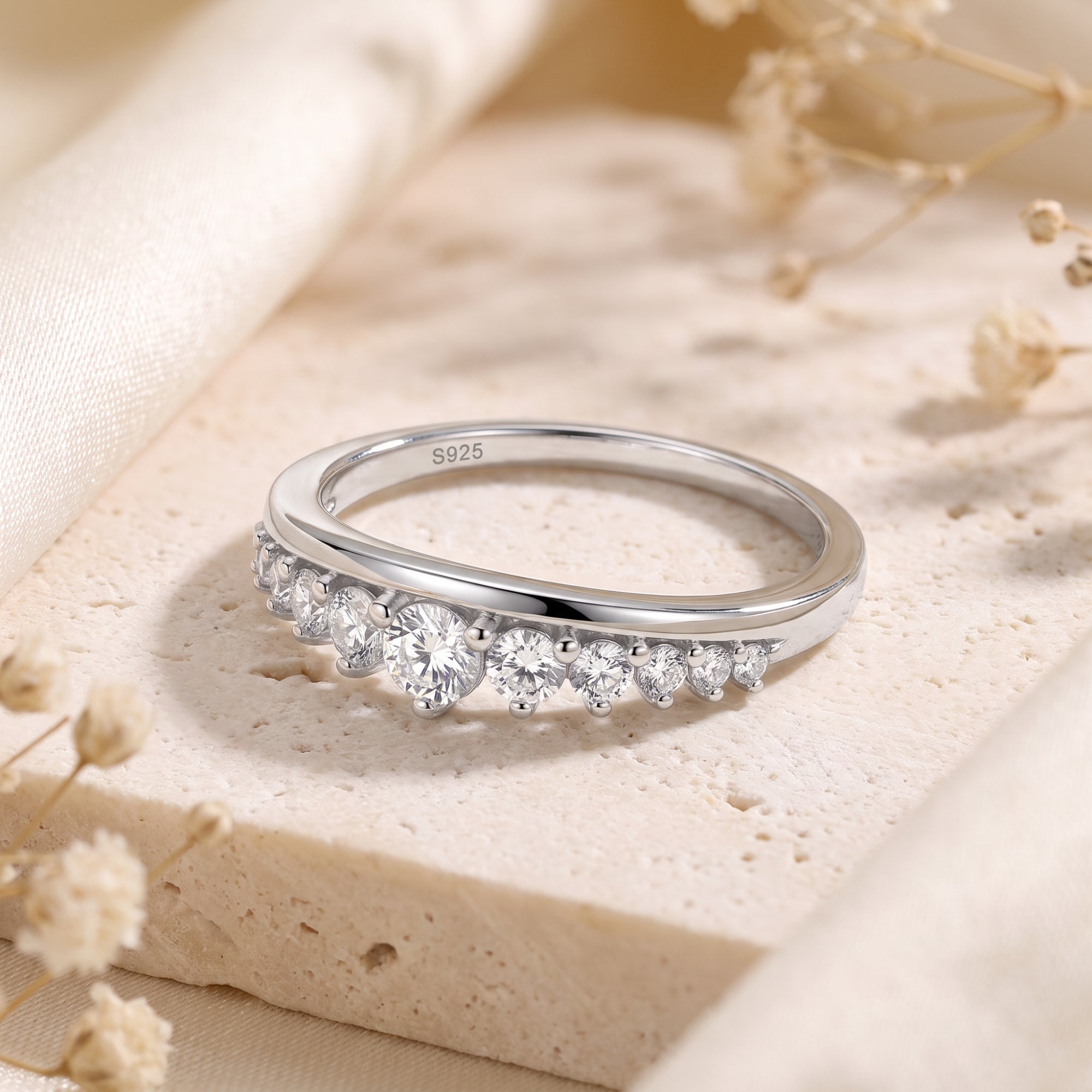 Sterling silver curved band with round cubic zirconia and S925 hallmark.