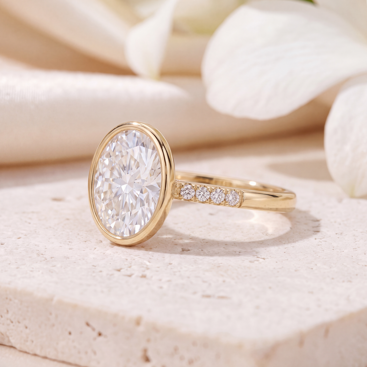 Side perspective view of the yellow gold oval moissanite bezel ring detailing the setting and band.