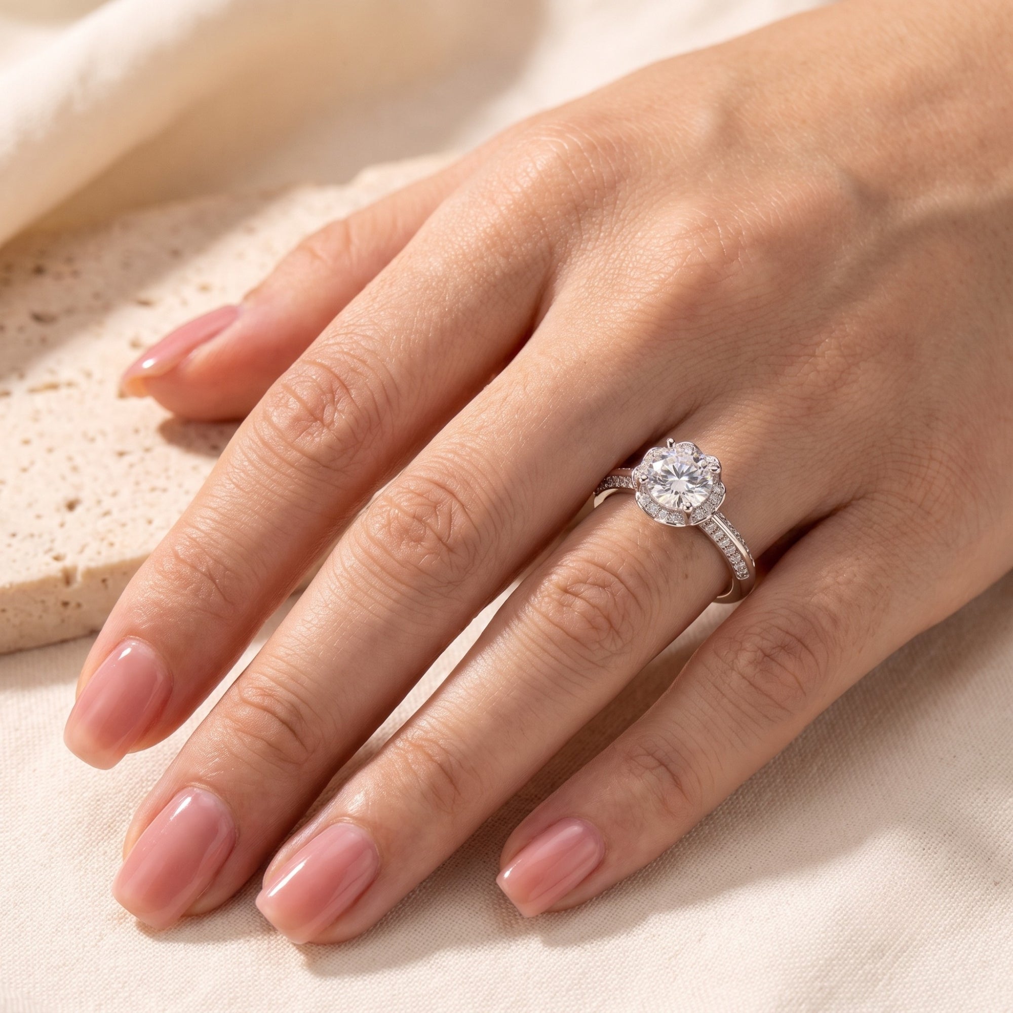 Top view of silver Fleur Bloom promise ring on a model's finger.