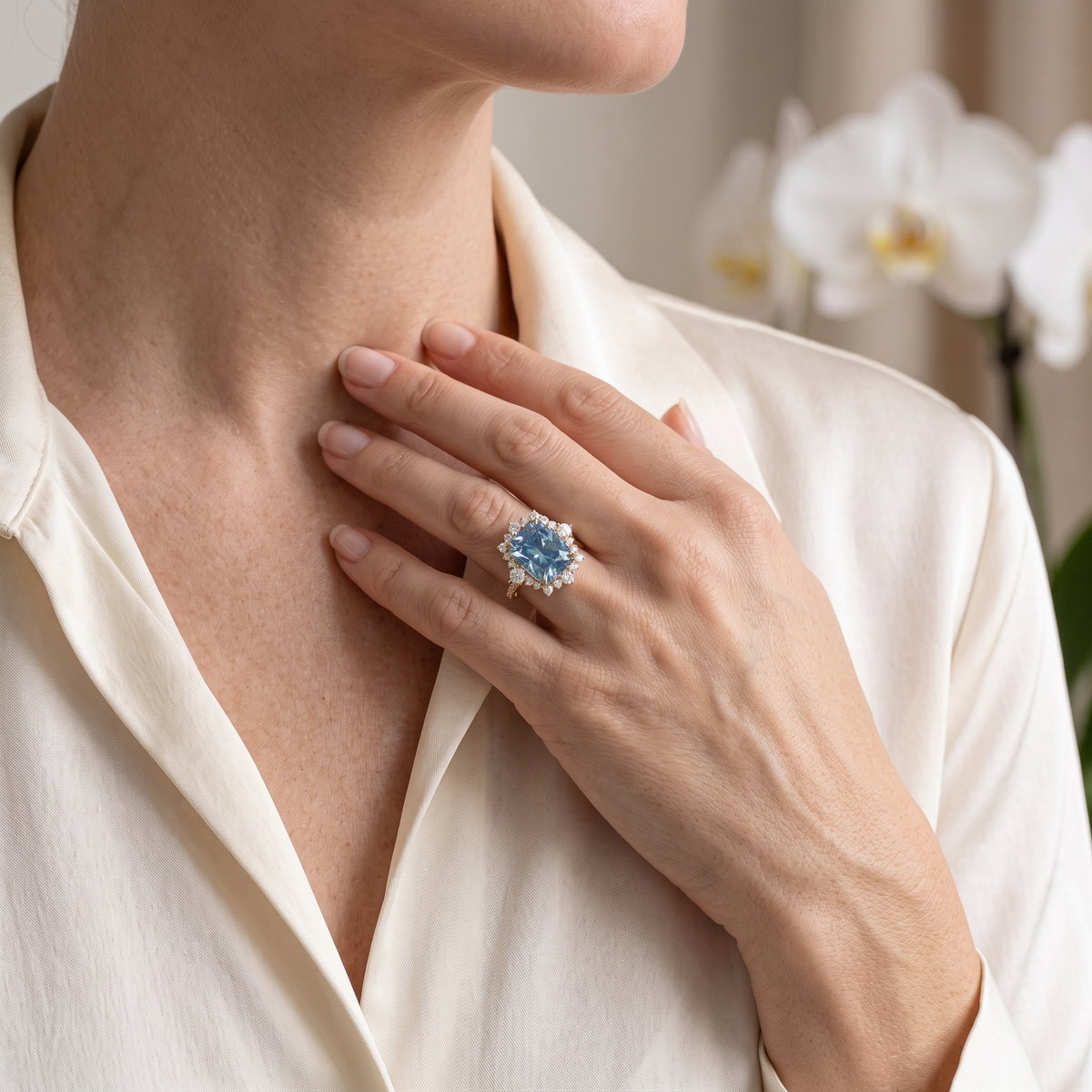 Lifestyle shot of a model wearing a yellow gold cushion-cut blue moissanite ring.