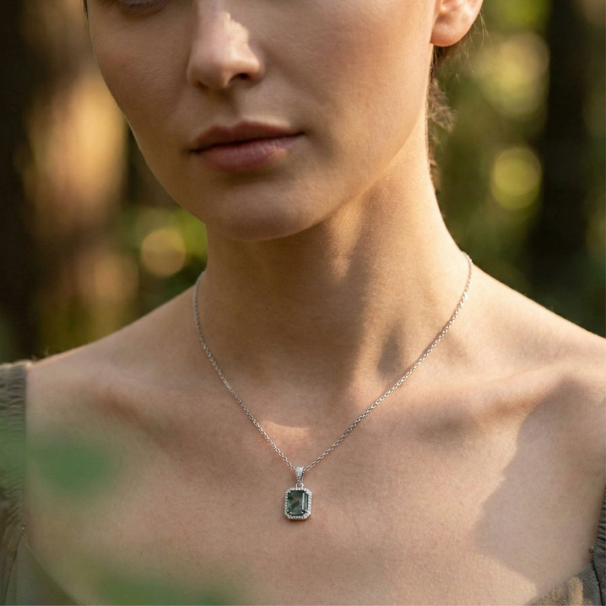Rectangular moss agate pendant necklace in S925 sterling silver worn by a model in a natural outdoor setting.