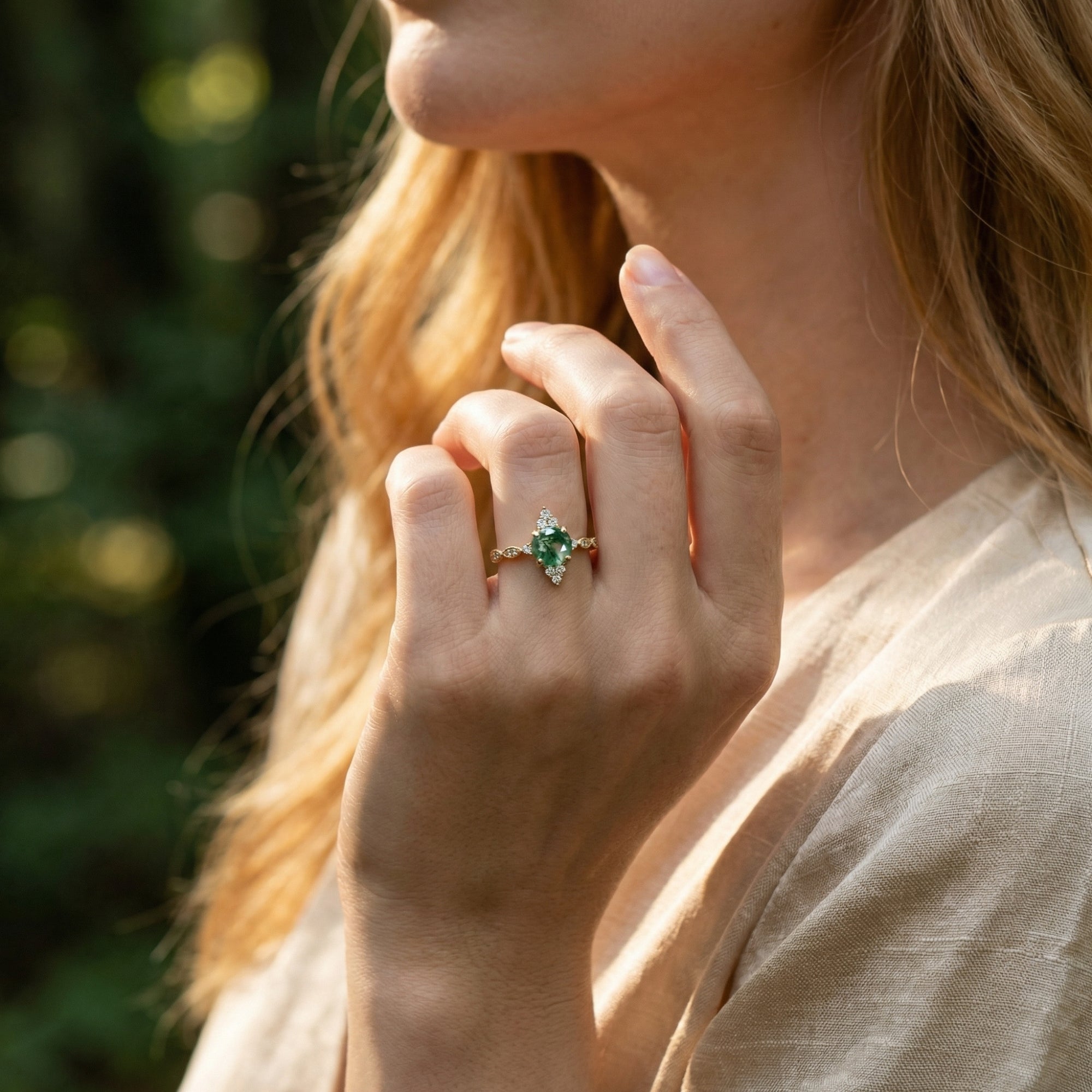 Gold moss agate sunburst ring worn by a model, showcasing the jewelry's elegant design in natural light.