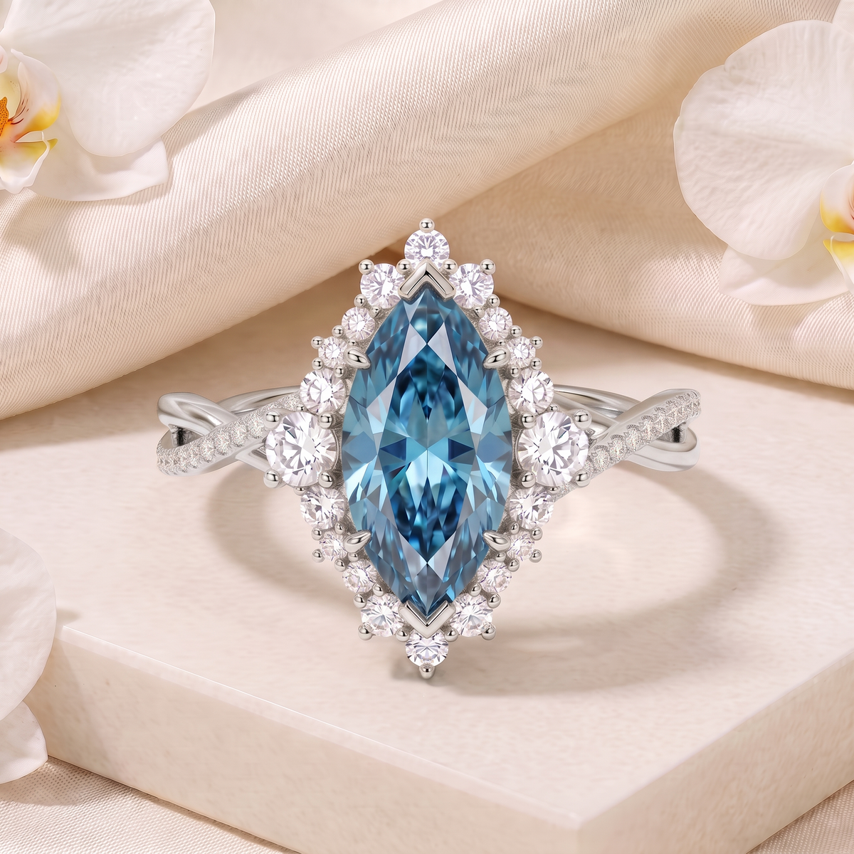 Front-facing view of a white gold ring featuring a blue marquise-cut center stone with a diamond halo on a twisted pavé band.