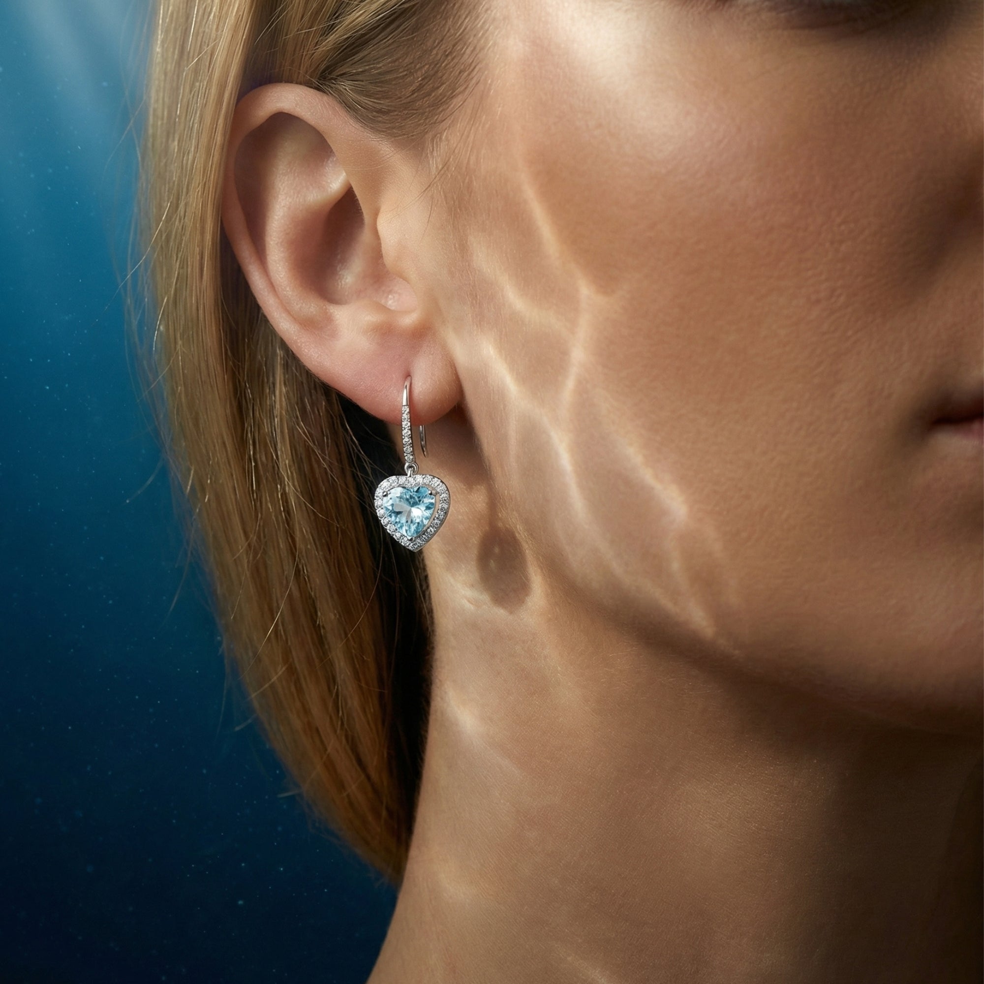 Model wearing the Aqualisse platinum and heart-cut aquamarine drop earrings with oceanic light effects.