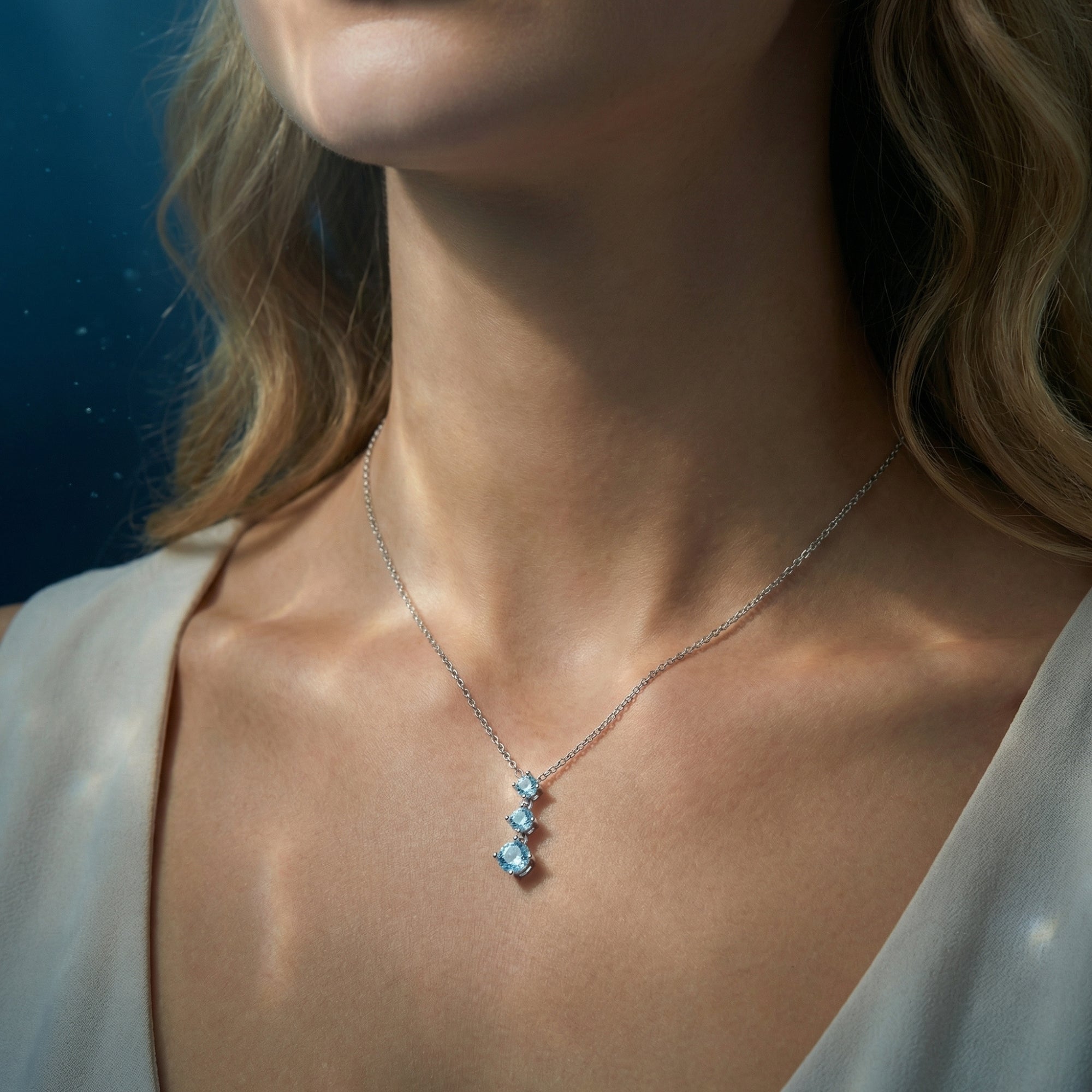 Lifestyle view of a model wearing the Nereid Flow graduated aquamarine necklace in platinum.