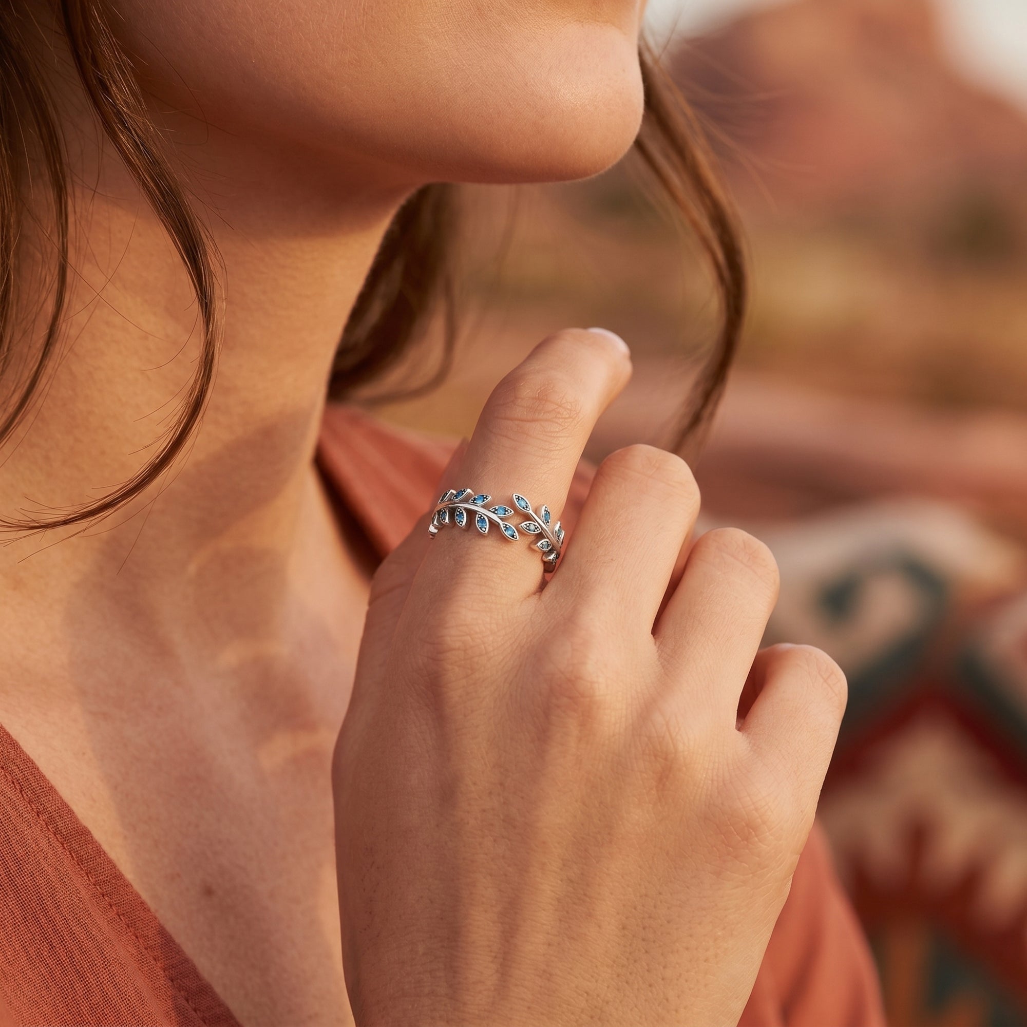 Model wearing the adjustable silver leaf ring with turquoise accents, highlighting its modern bypass design.