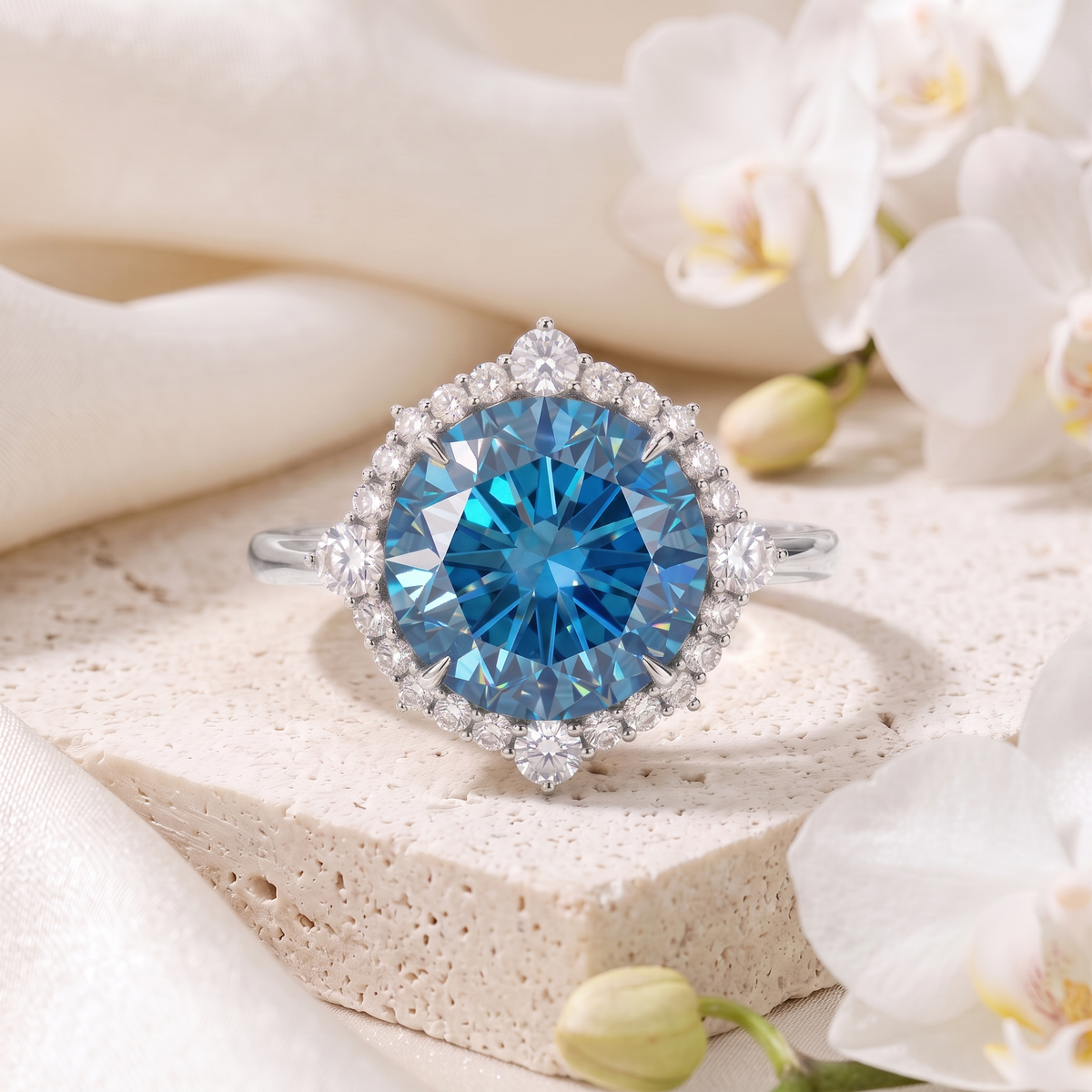 White gold blue moissanite halo ring featuring a round blue center gem surrounded by small white stones.