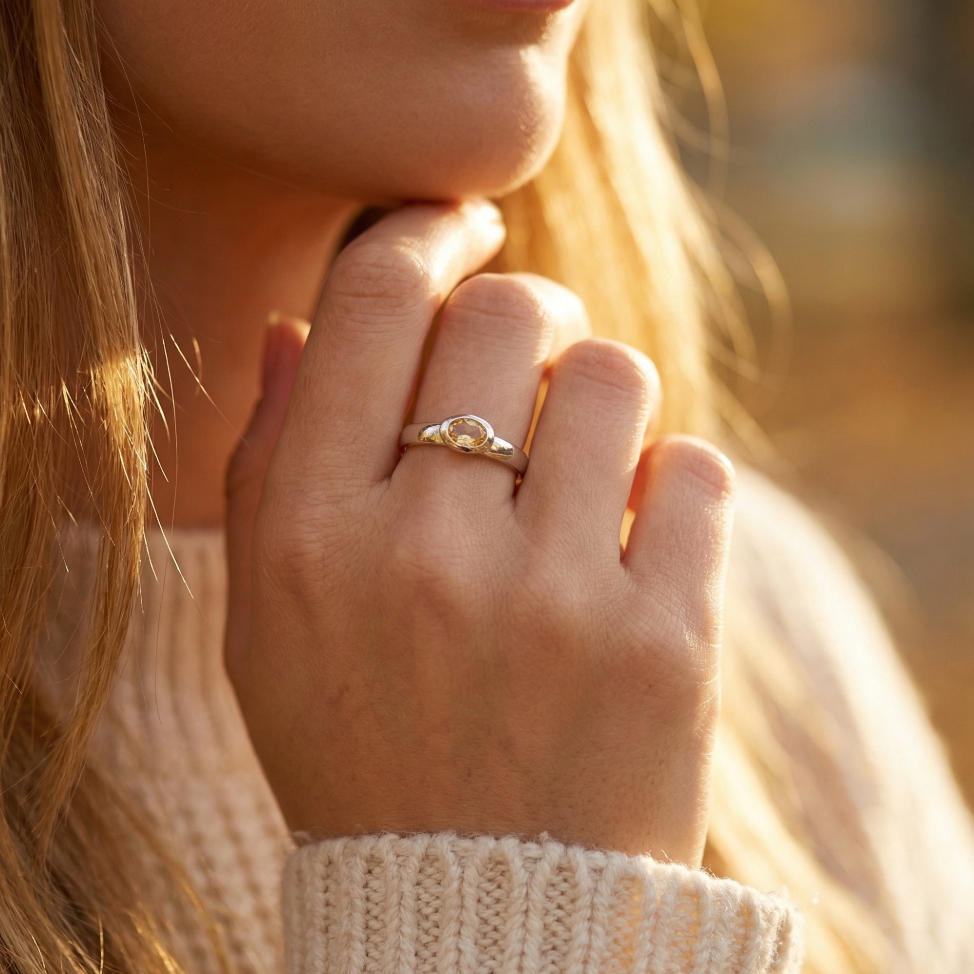 Sterling silver Marigold ring with oval citrine worn on a woman's hand, showing the textured band.