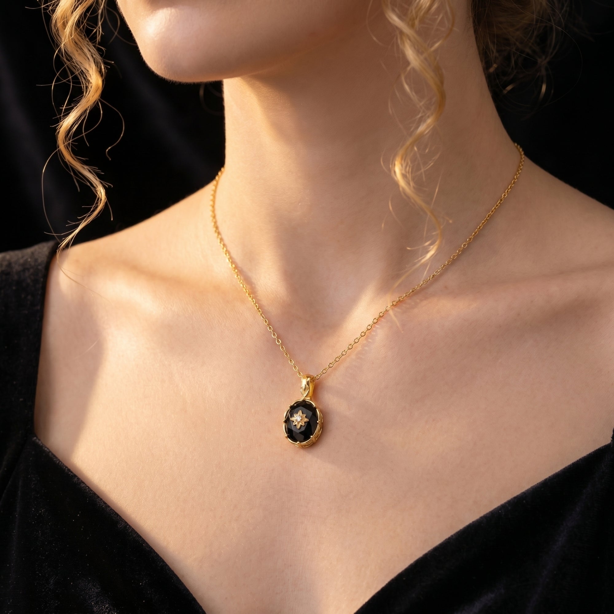 Close-up of the Monarch oval-cut black onyx and 18K gold plated pendant necklace worn by a model.
