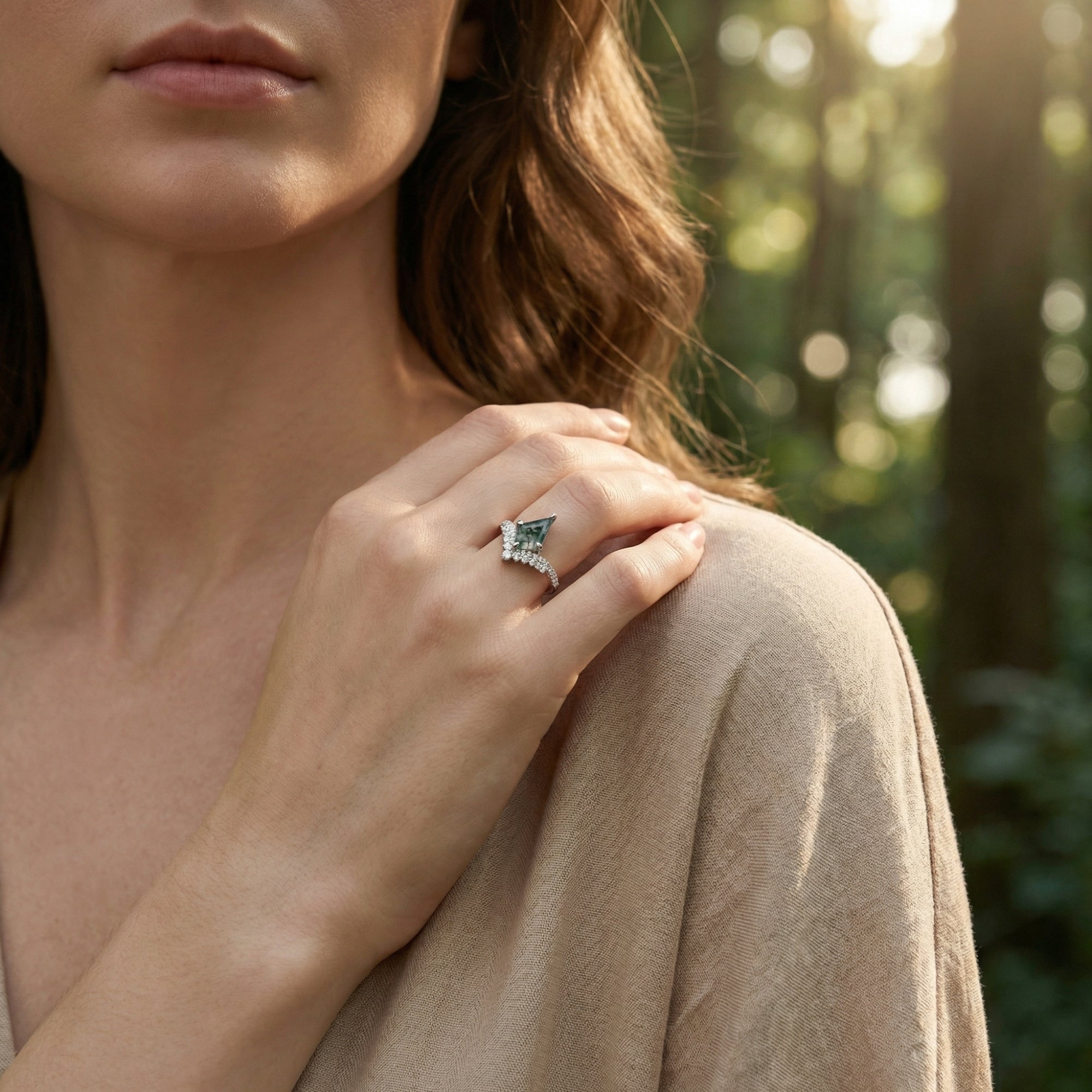Close-up of a woman wearing the S925 sterling silver kite cut moss agate ring in a natural forest setting.