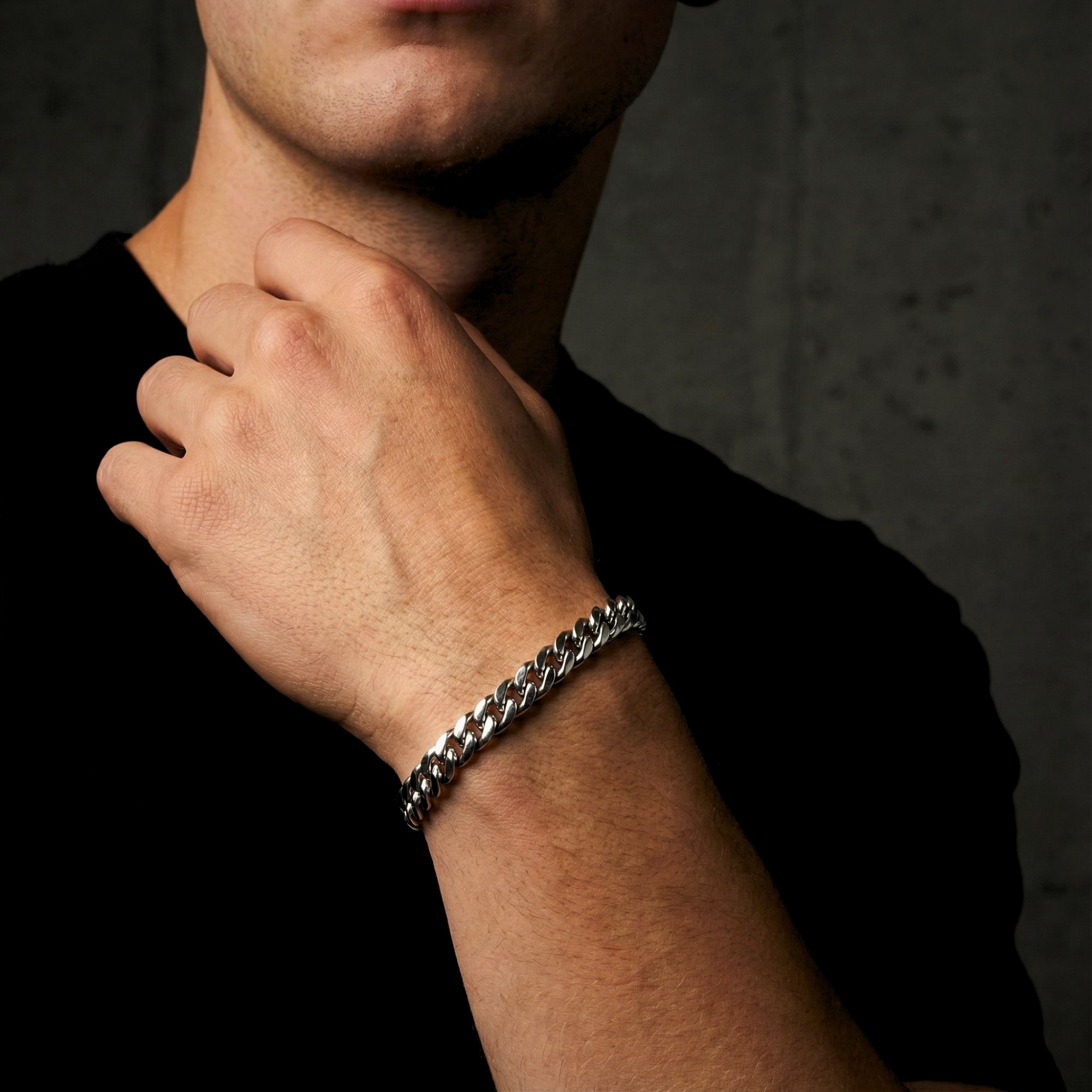 Side view of a man wearing the silver stainless steel Origin Link Bracelet on his wrist.