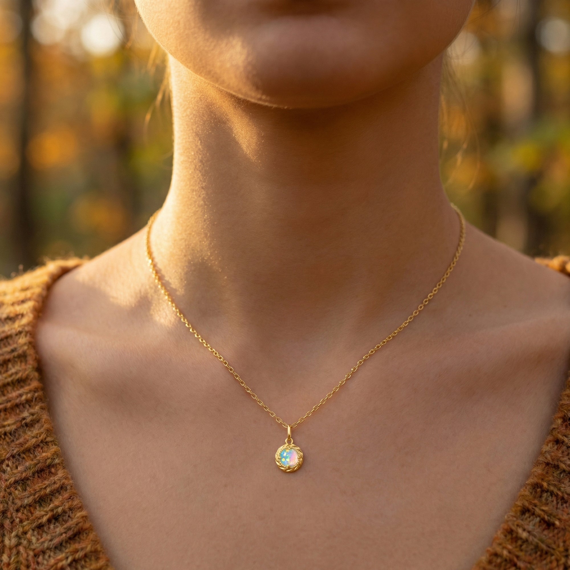Frontal view of the Valyria round opal pendant necklace in gold-tone sterling silver on a model.