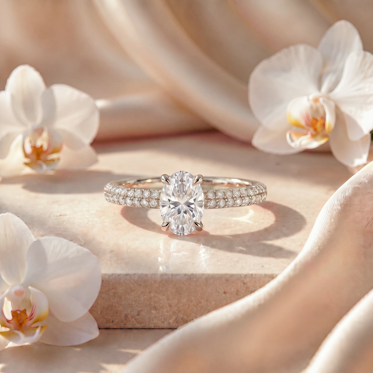 White gold oval moissanite engagement ring with double-row pavé band.