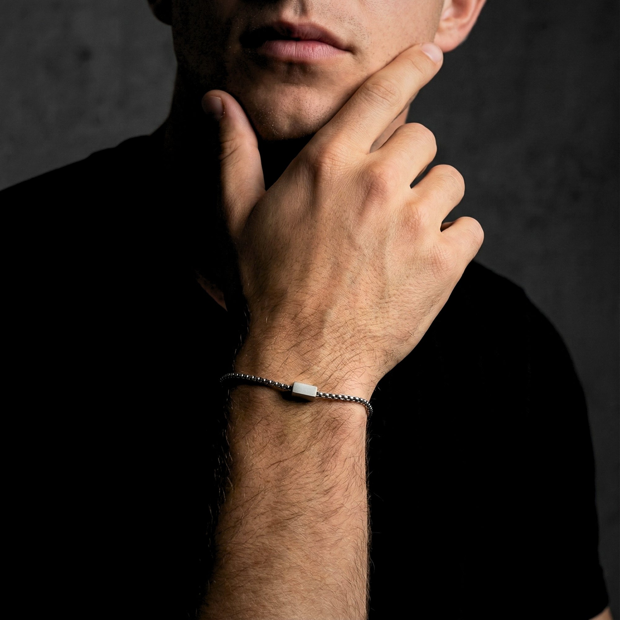 Close-up of a 5mm silver stainless steel link ID bracelet on a man's wrist with a polished finish.