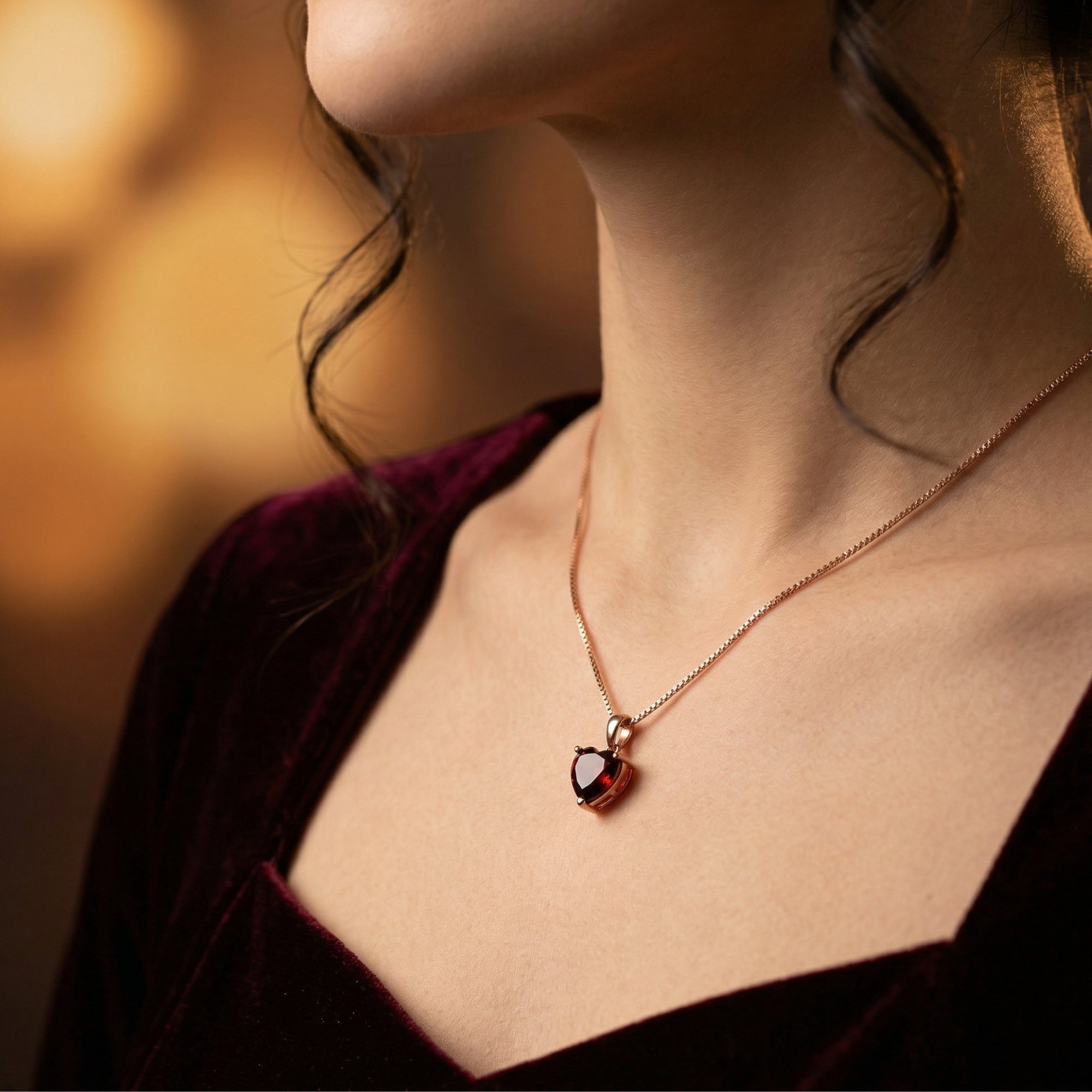 Model wearing the heart cut garnet necklace in 18K rose gold with a velvet dress.