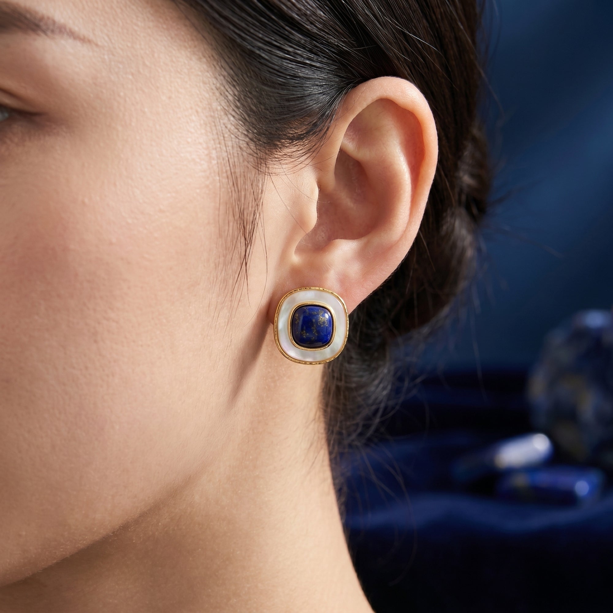 Side view of a model wearing the Nefertiti natural lapis lazuli and gold-plated cushion stud earring.