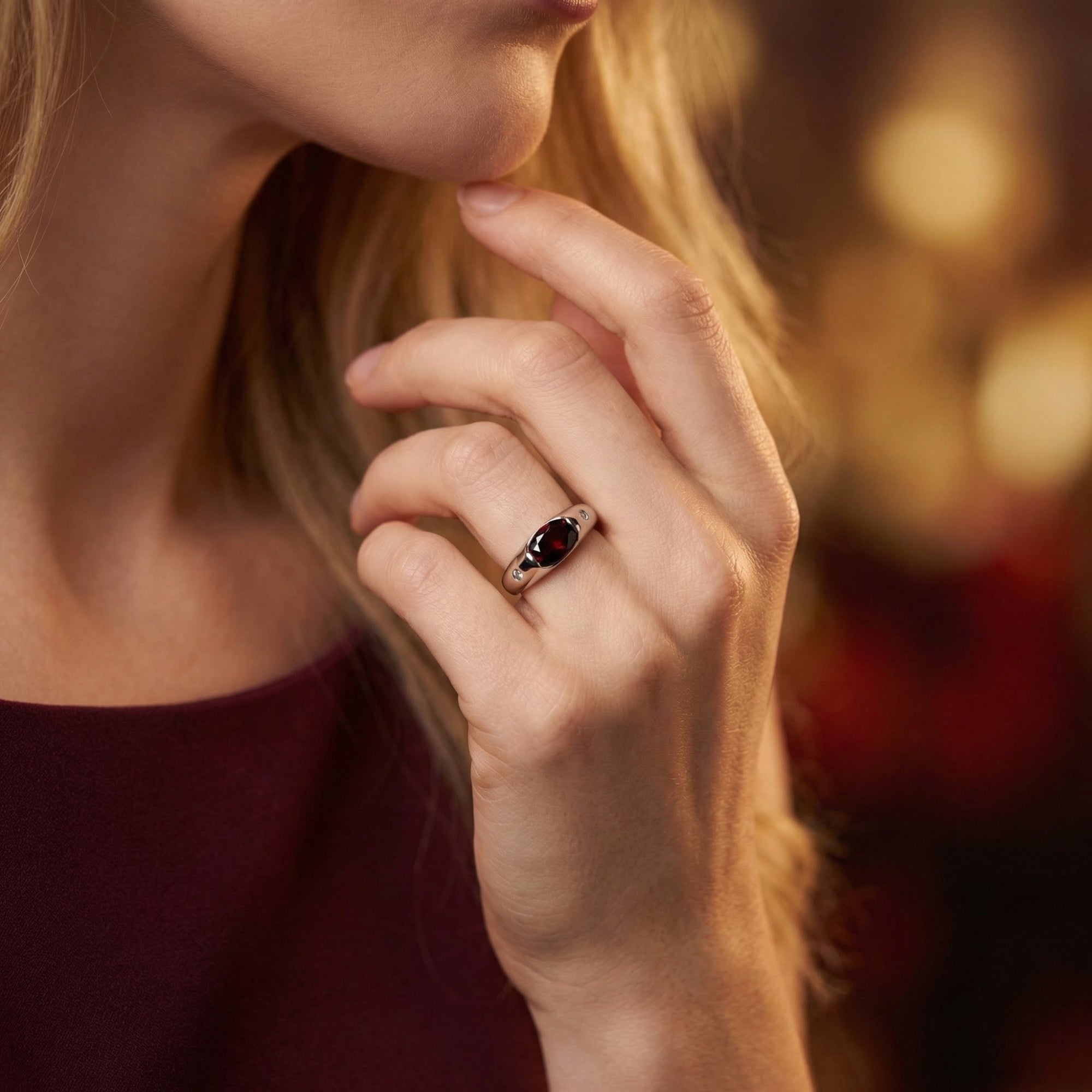Model wearing the sterling silver Vaelia ring featuring a deep burgundy oval garnet.