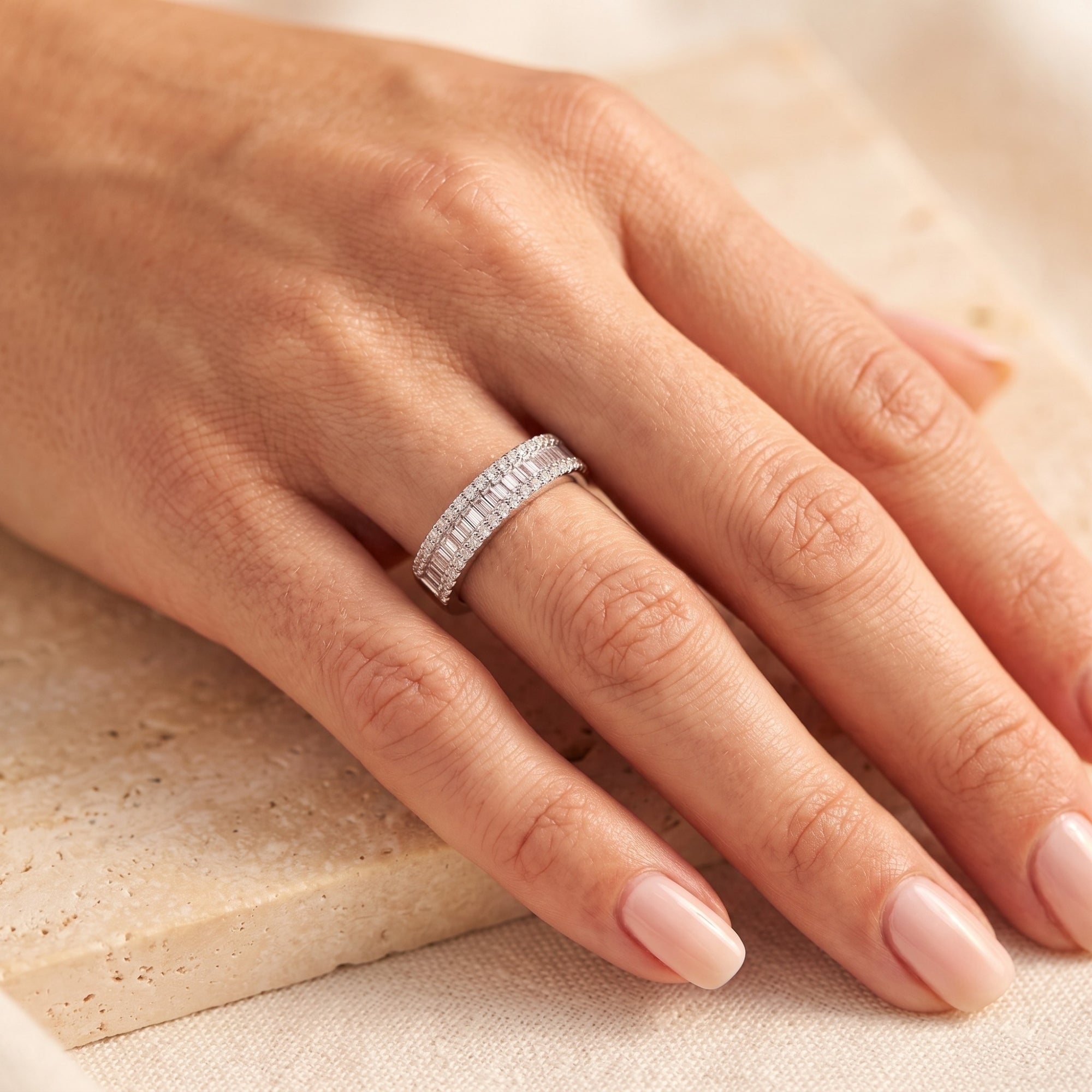 Sterling silver baguette cubic zirconia band worn on a finger, showing the pavé borders and comfort-fit design.