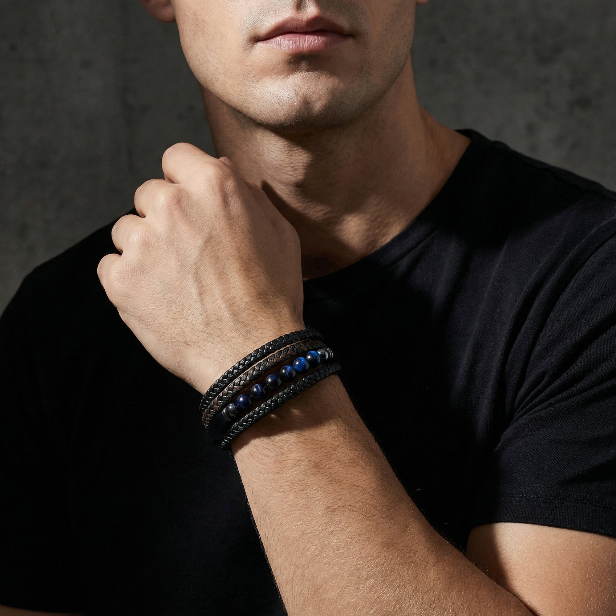 Close-up of a man wearing the multi-layered Eclipse leather bracelet with blue beads and black stainless steel clasp.