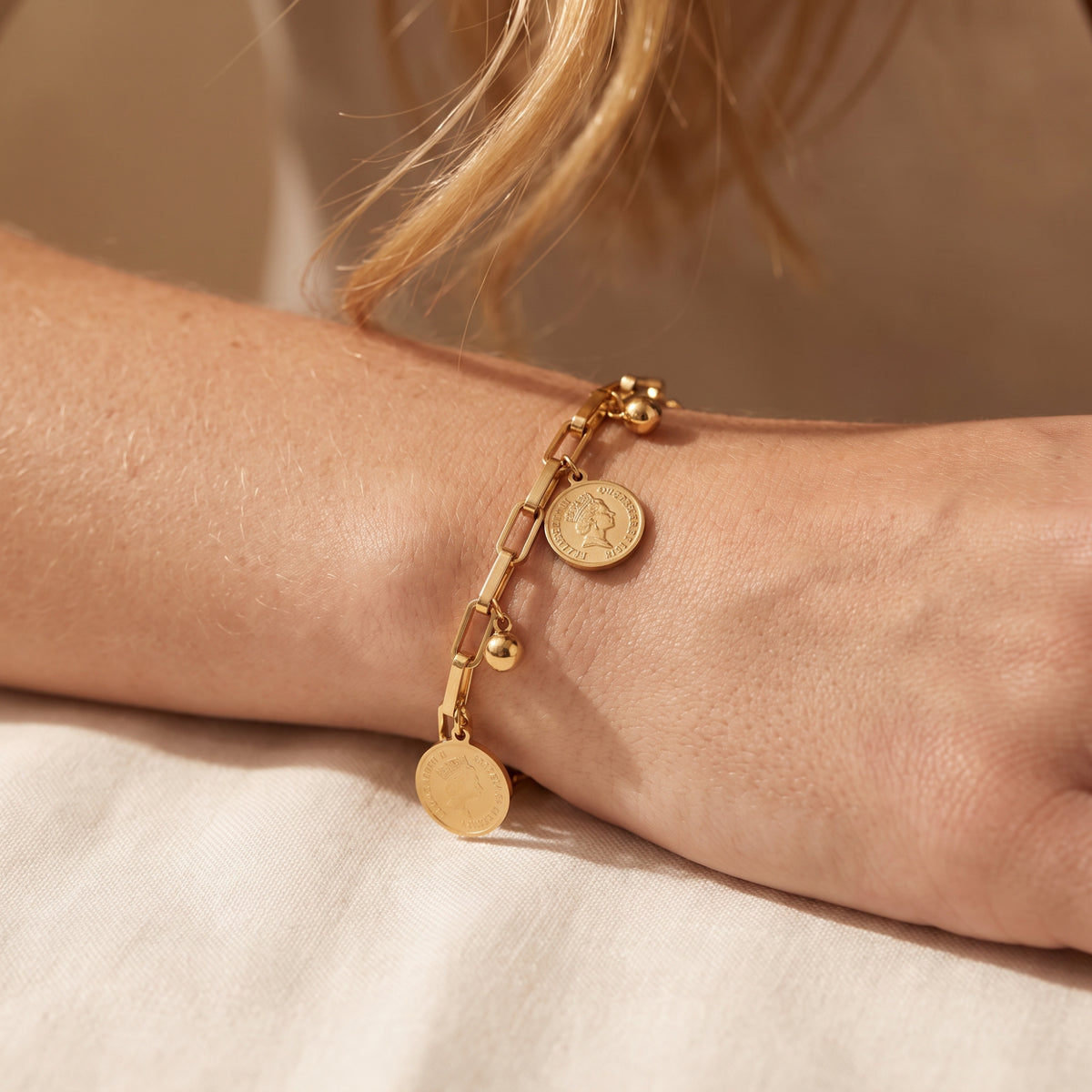 La pulsera de eslabones con dije de moneda