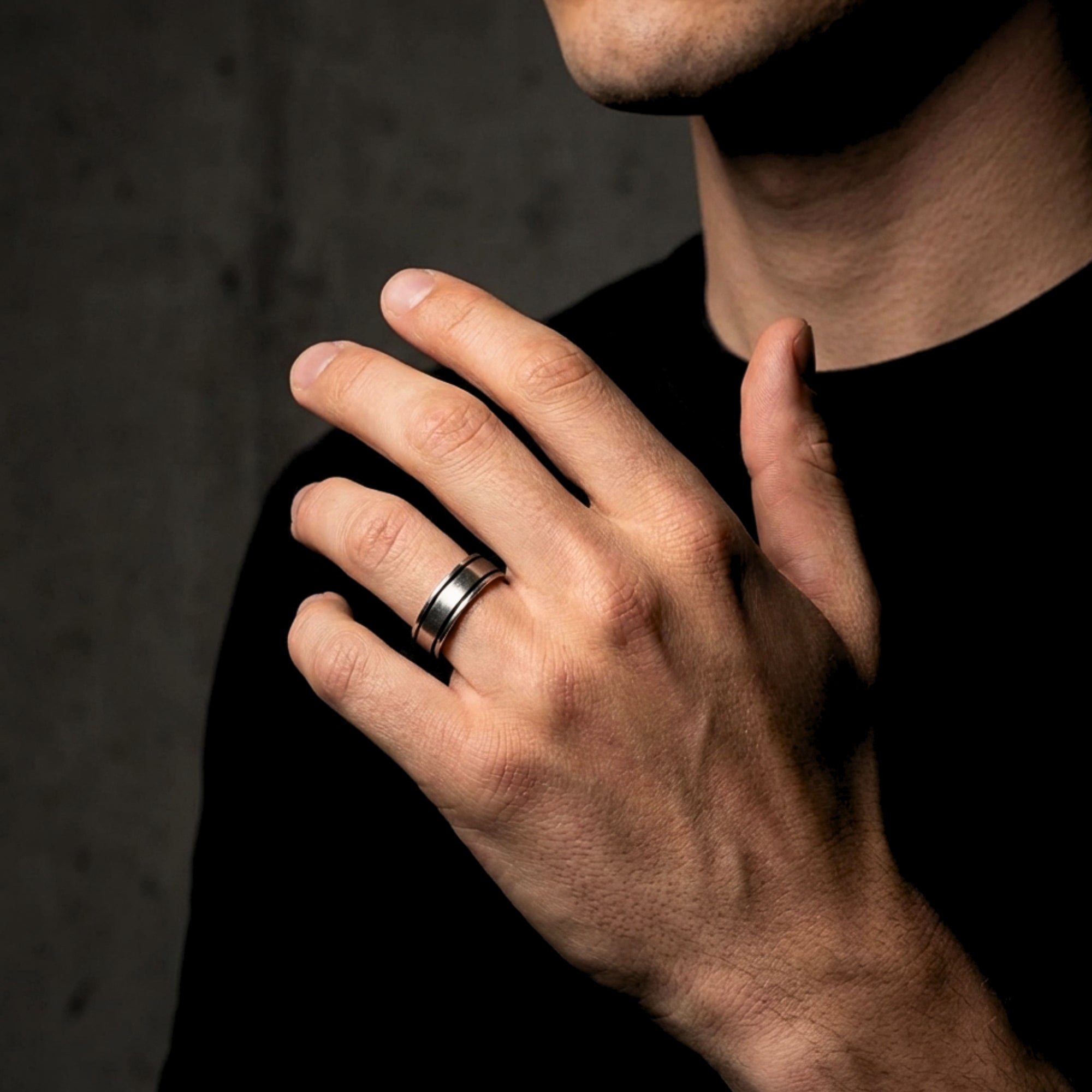 Silver stainless steel Horizon ring for men shown on a model's hand against a dark background.