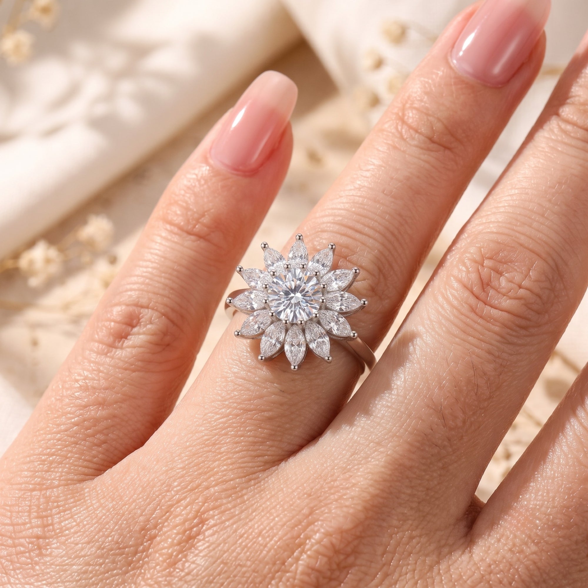 Sterling silver Solar Bloom ring with cubic zirconia accents shown on a finger for scale.