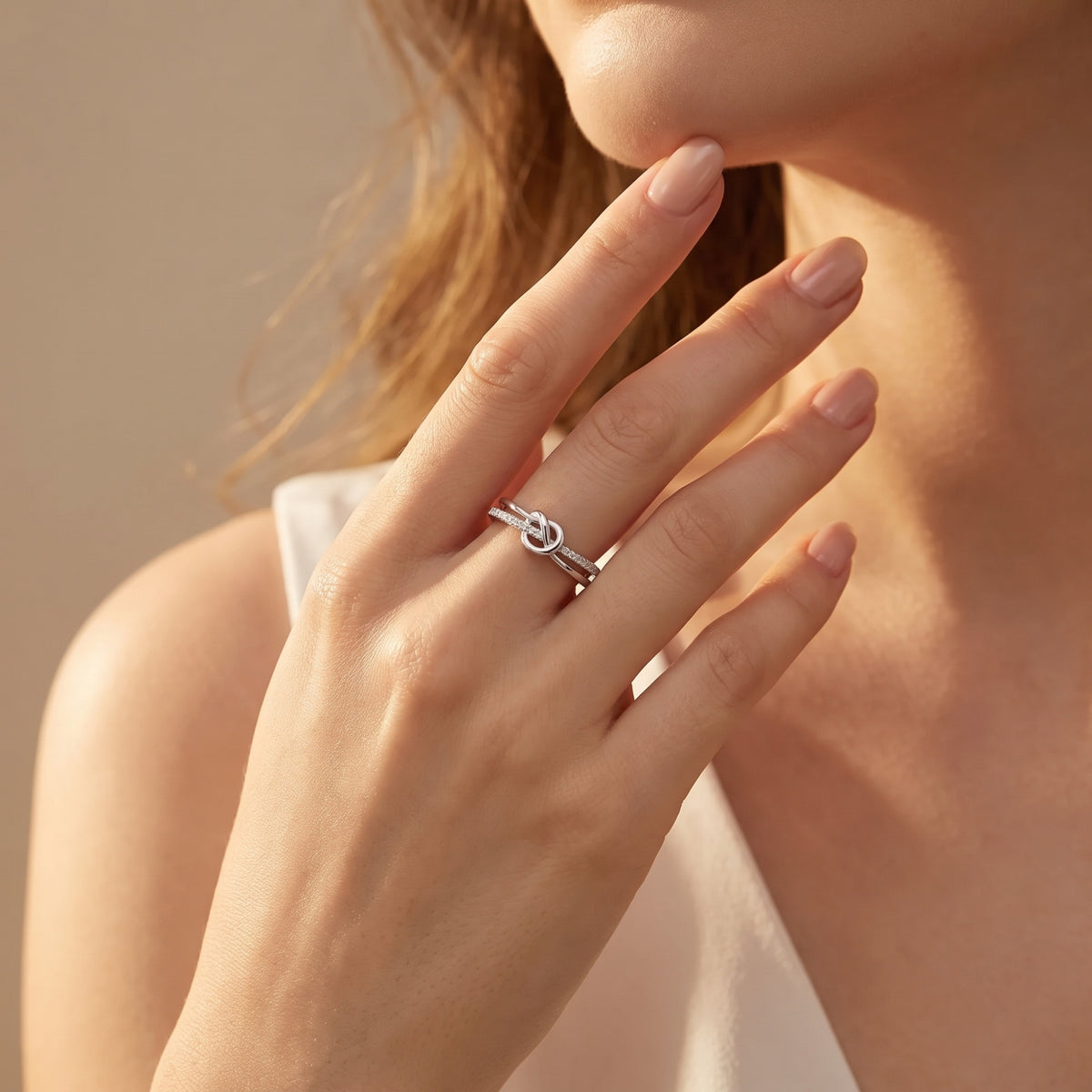 Silver heart and infinity knot ring worn on a hand