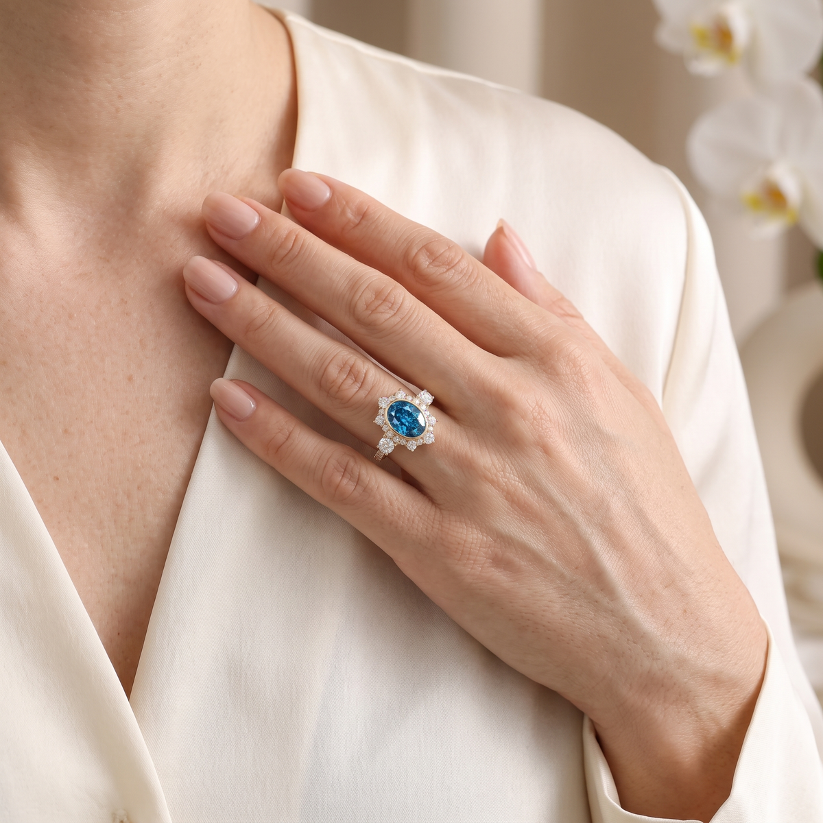 Lifestyle view of a model wearing the rose gold oval blue moissanite halo ring placed against her chest.