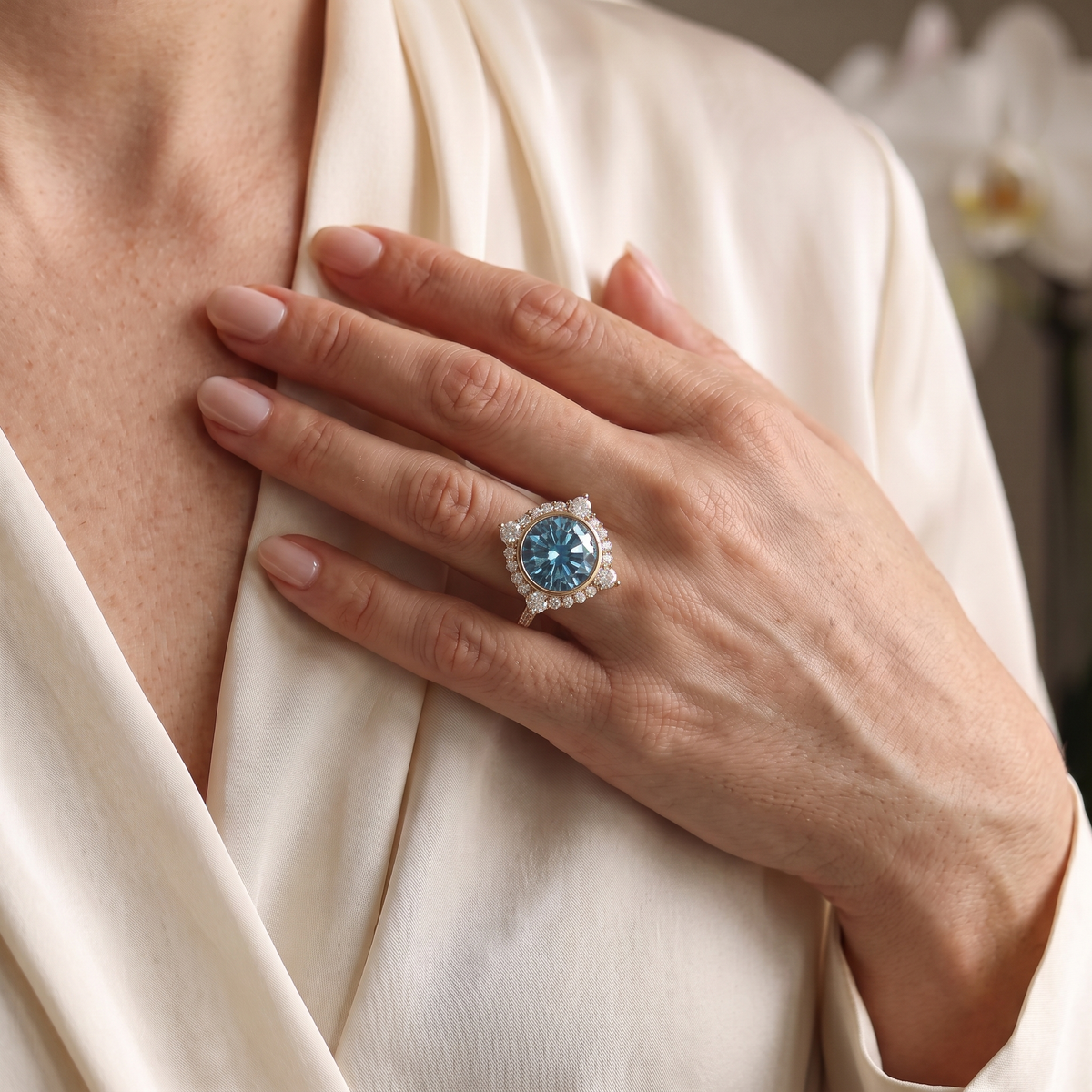 Model wearing round cut blue moissanite statement ring in rose gold.