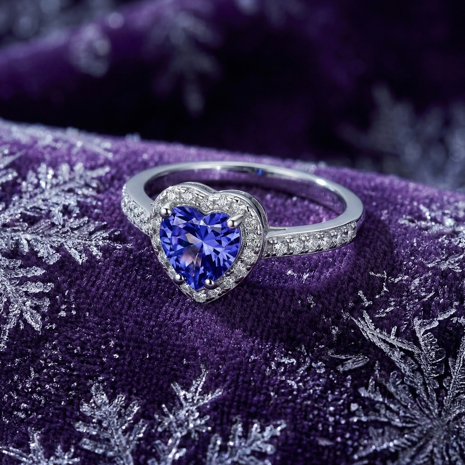 Heart-shaped simulated tanzanite silver ring with a diamond halo on purple velvet with snowflake patterns.