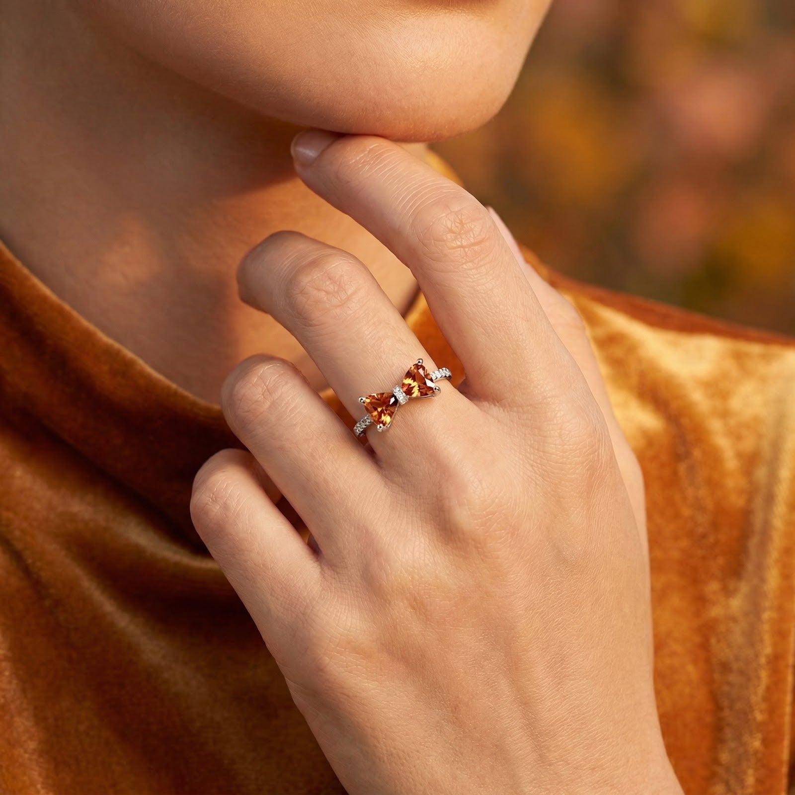 Model wearing the sterling silver Clarabelle bow ring with honey gold simulated topaz stones on her finger.