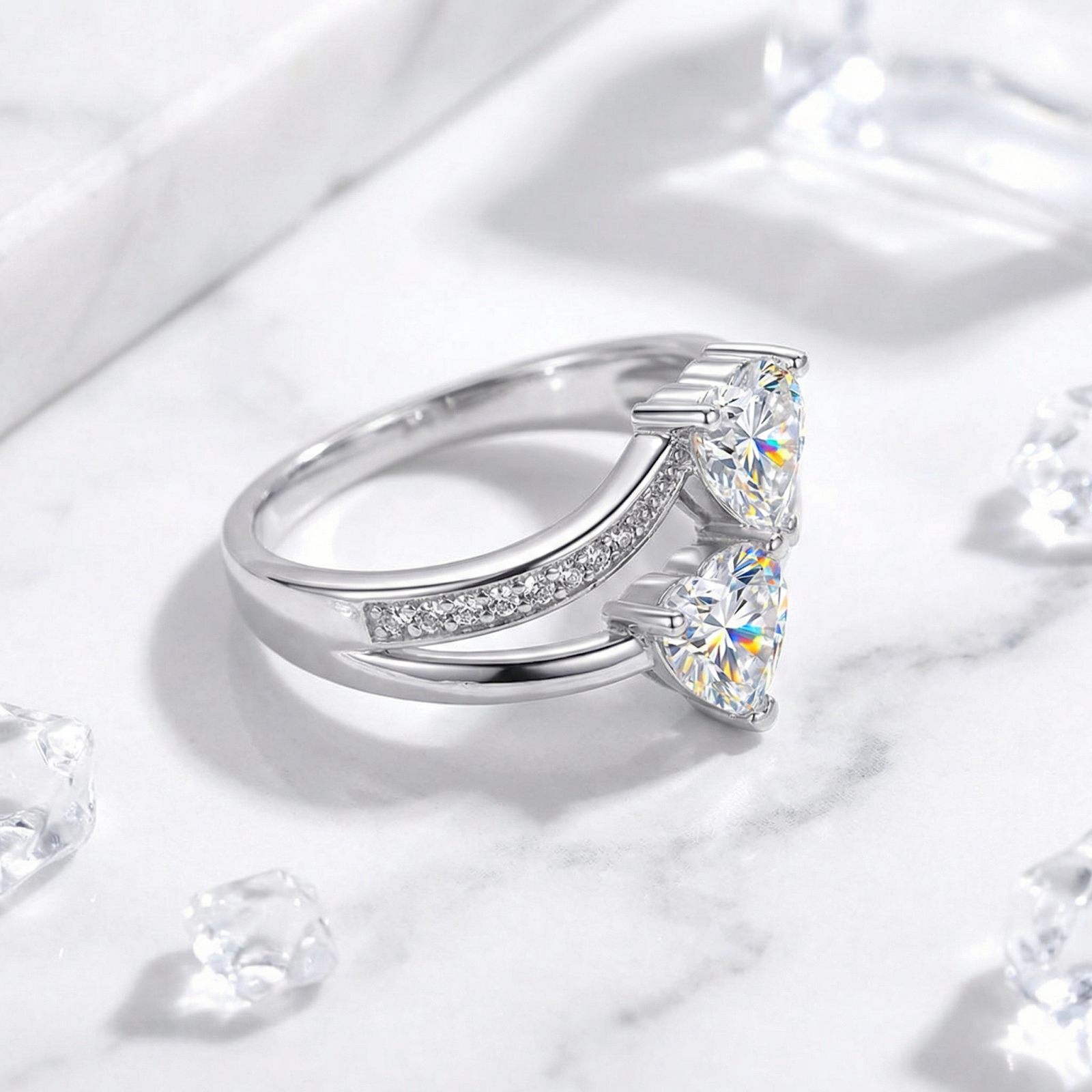 Side view of the Amantina S925 sterling silver bypass ring featuring two heart-cut zirconia stones on marble.