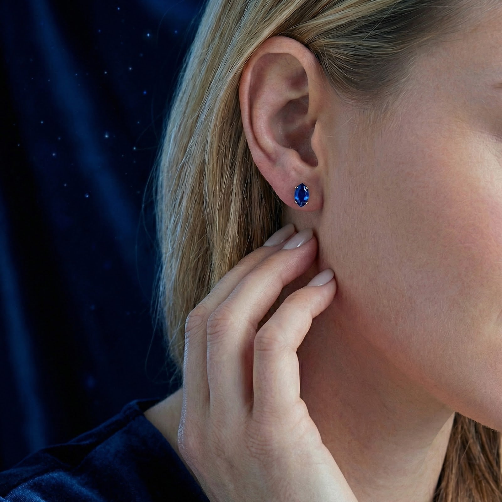 Model wearing the Adalind marquise cut simulated sapphire stud earring in 18K gold vermeil on her ear.
