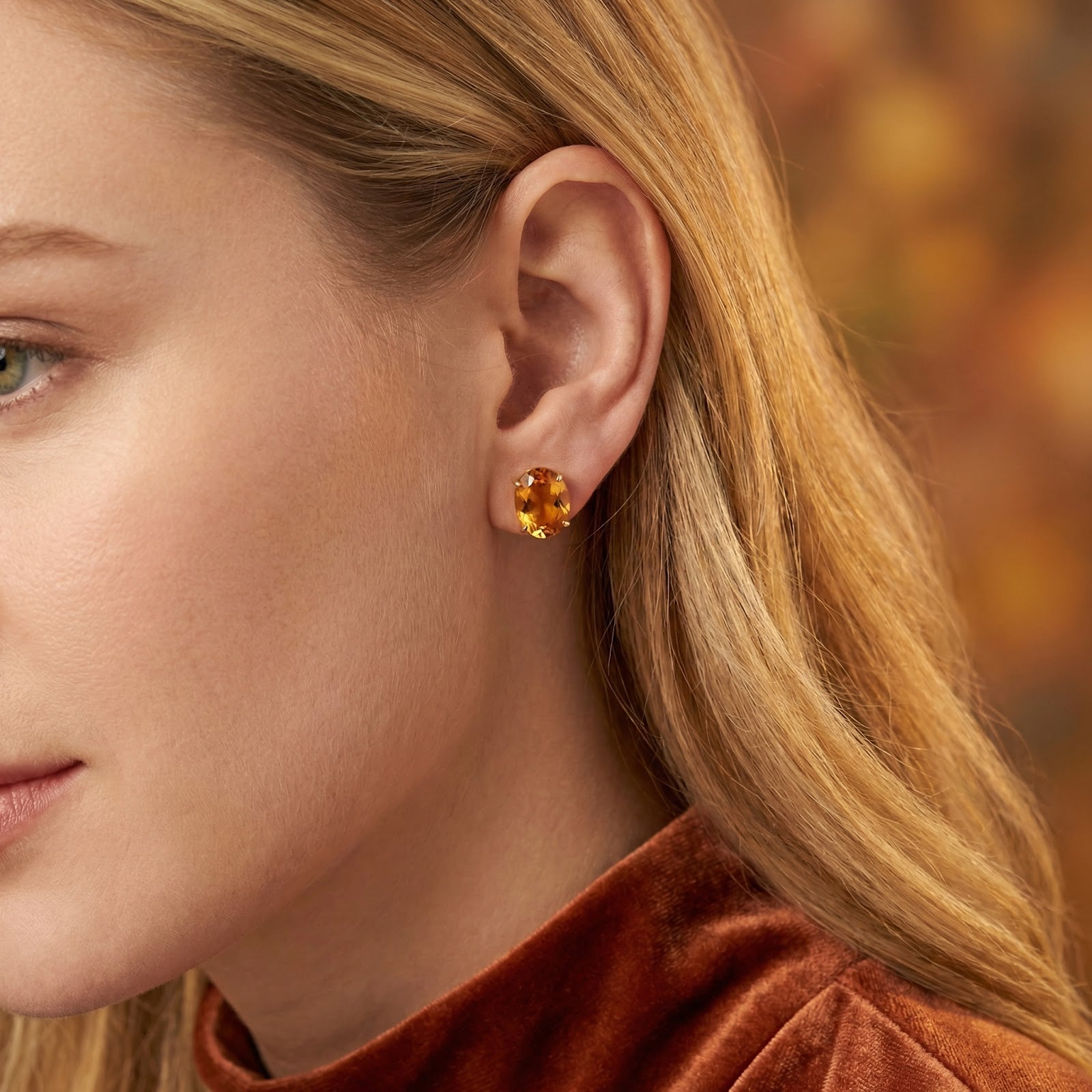 Side view of a model wearing the Amarantha gold vermeil and simulated topaz stud earrings.