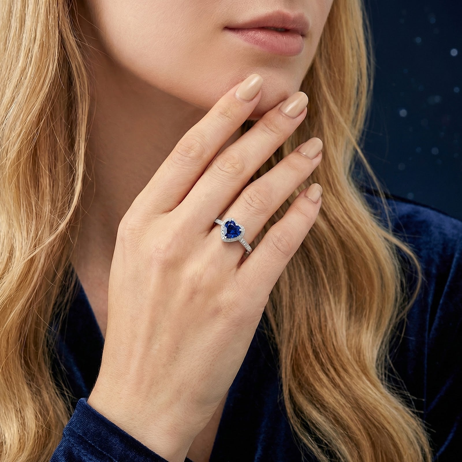 Model wearing the heart-cut simulated sapphire sterling silver ring on her finger for a lifestyle look.