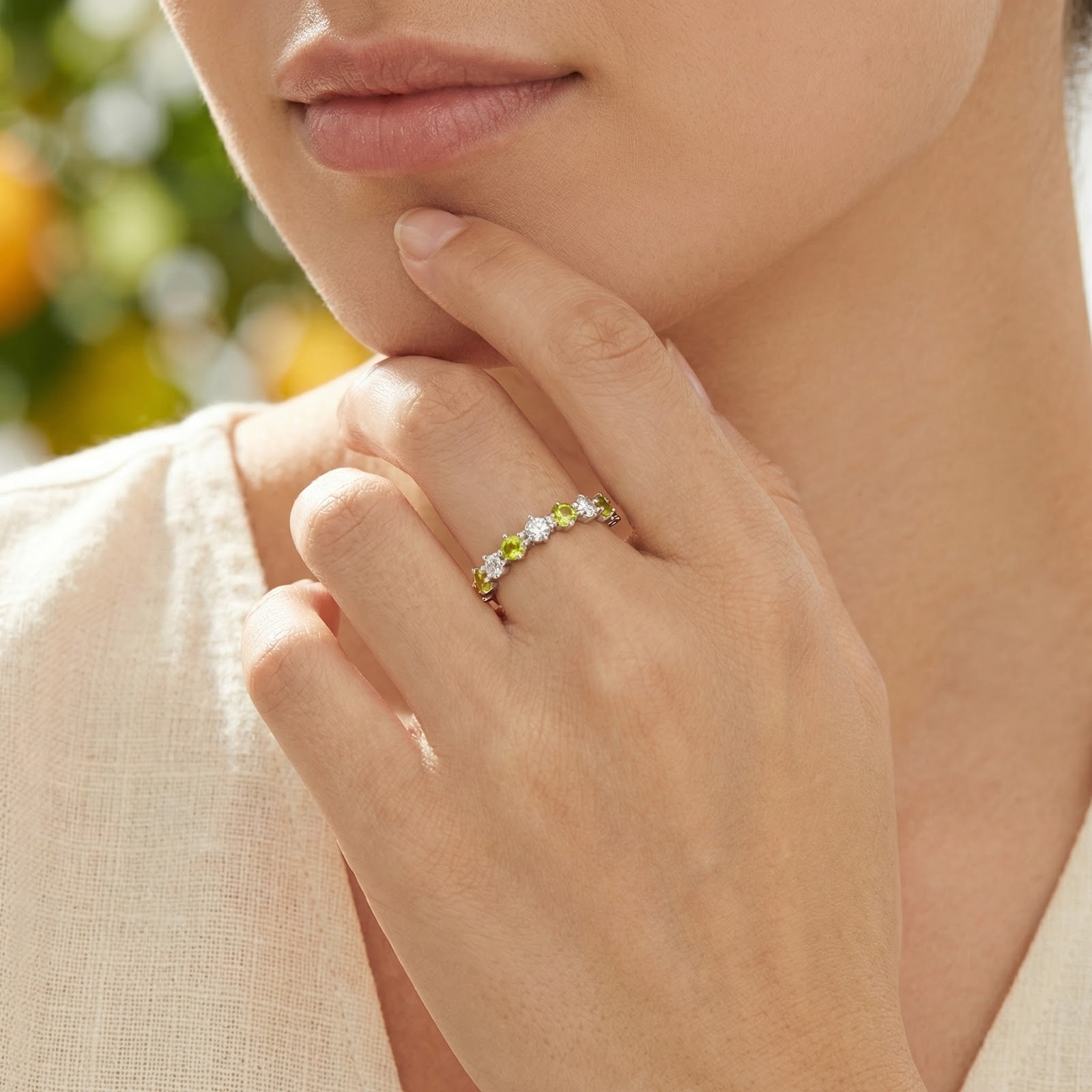 Woman wearing the sterling silver simulated peridot row ring on her finger.