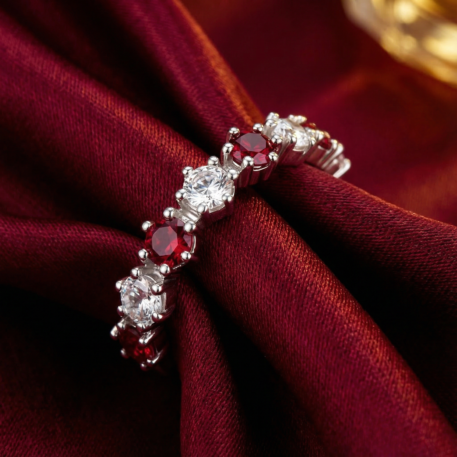 Macro view of the S925 sterling silver prong setting and round-cut simulated rubies on the Rubielle eternity ring.