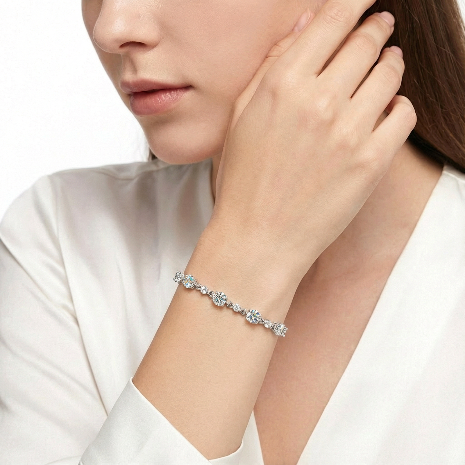 Women's sterling silver bracelet with oval cut simulated diamonds worn with a white blouse.