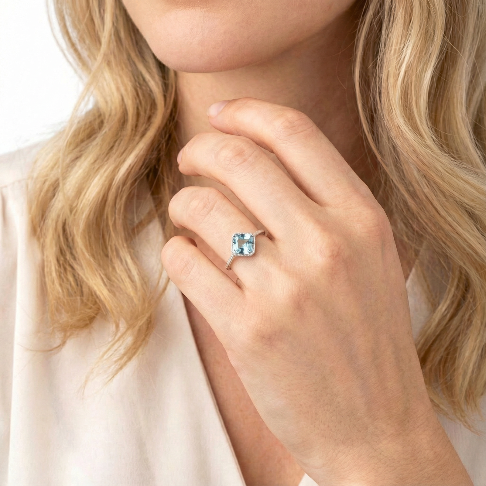 Model wearing the Aquila sterling silver ring featuring a cushion cut light blue simulated aquamarine stone.
