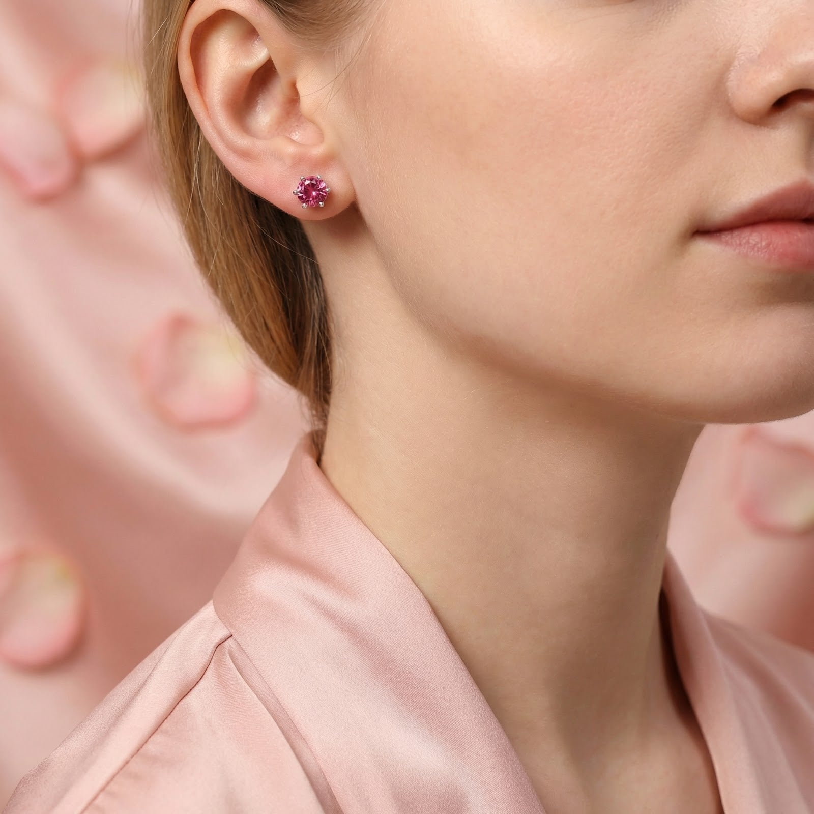 Model wearing a round simulated pink tourmaline stud earring in sterling silver on her ear.