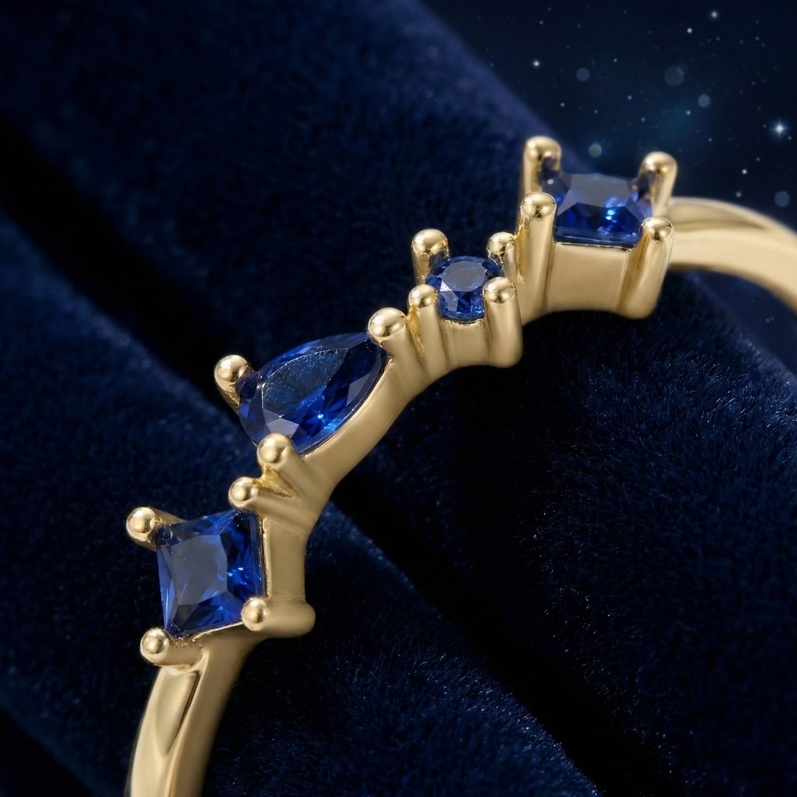 Close-up of the Nyara V-ring's 18K gold vermeil prongs and multi-cut simulated blue sapphires.