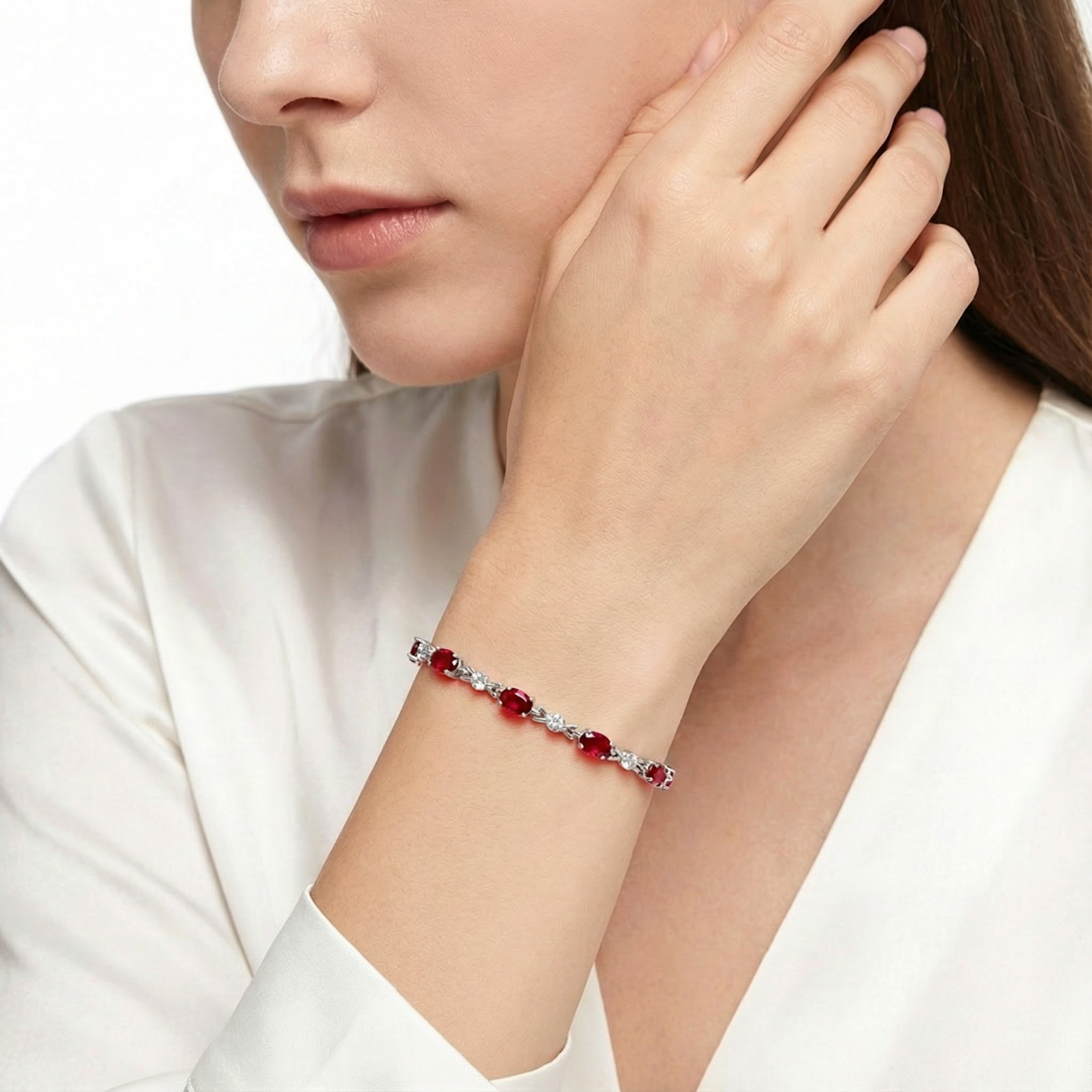 A model wearing the Vivara oval-cut simulated ruby bracelet in sterling silver with a white blouse.